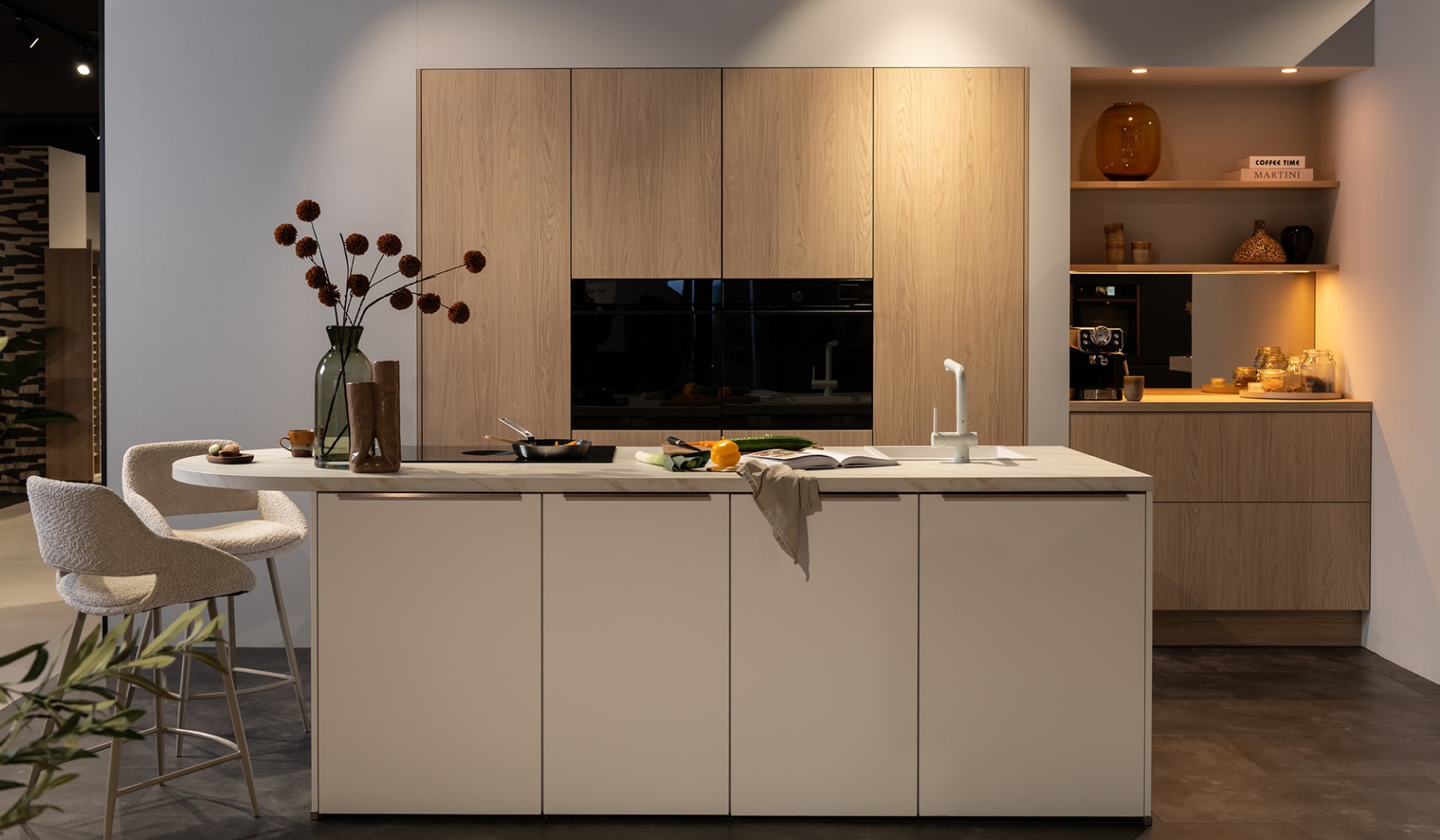 Een moderne keuken met beige kookeiland, houtlook kastenwand en ingebouwde apparatuur.