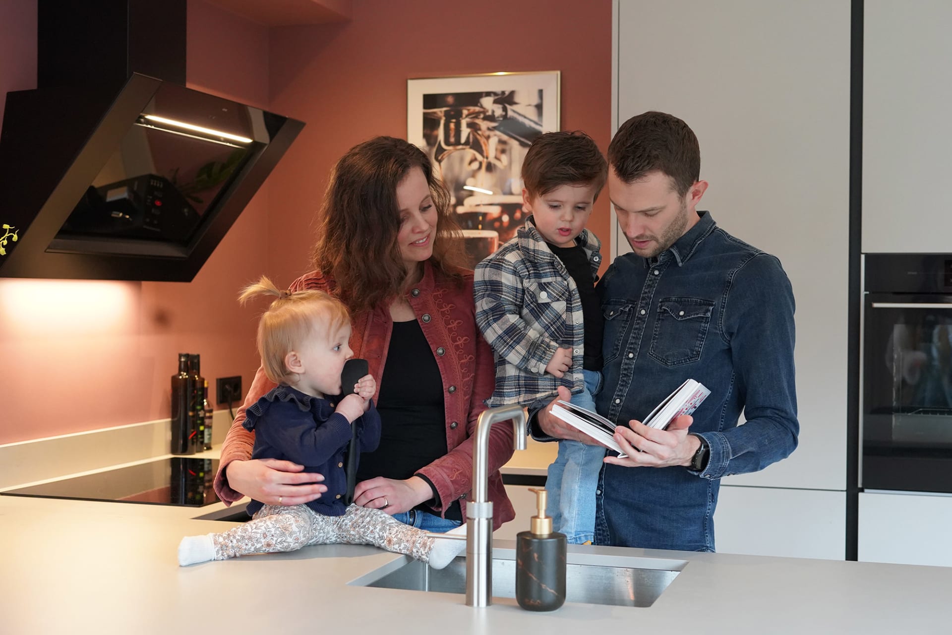 Lichte U-keuken van familie Vahl met keukenbar en roze wand