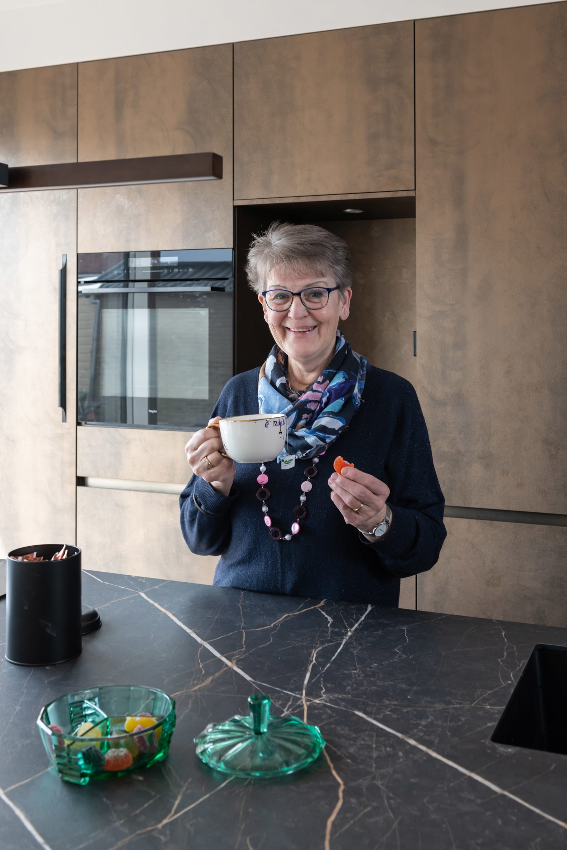 Roestkleurige fronten met greeplijsten in de keuken van Gerda en Jos