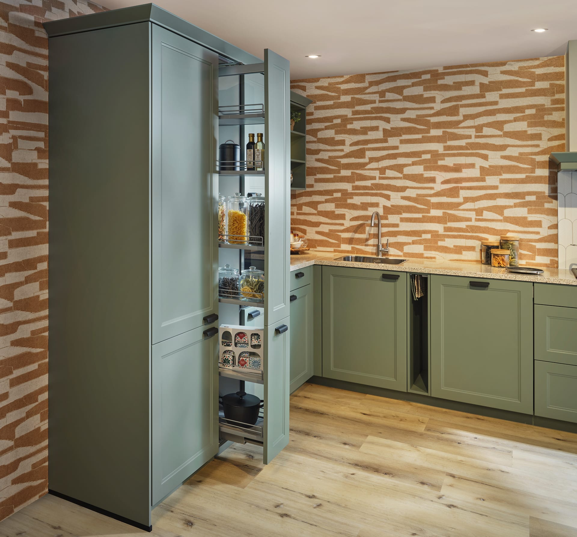 Groene keuken met kaderfronten en een uitgetrokken voorraadkast