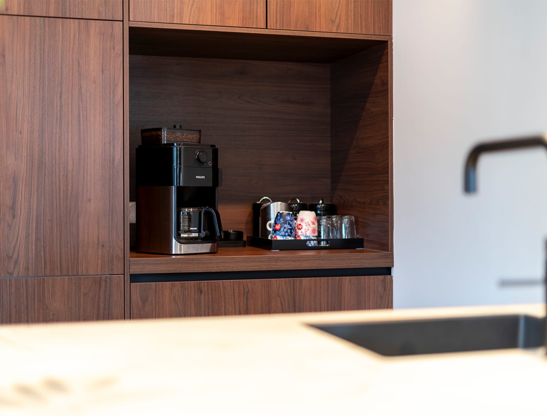 Koffiehoek met espressomachine in een notenhouten keukenkast
