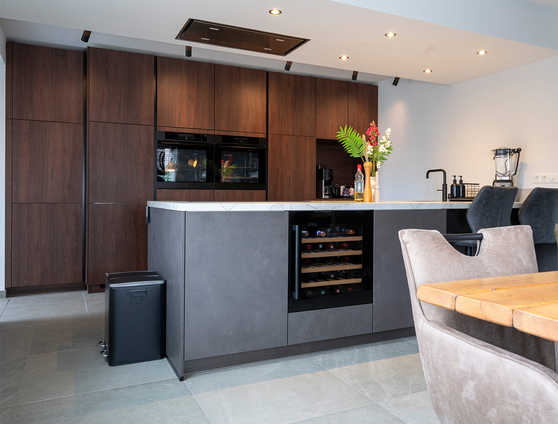 Woonkeuken met walnoothouten kastenwand en betonlook kookeiland