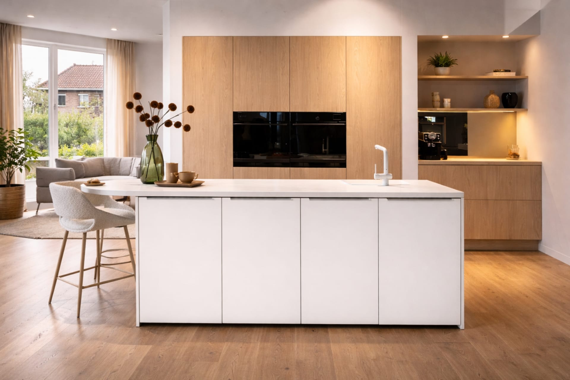 Scandinavische keuken met wit kookeiland, licht eiken kastenwand en zithoek