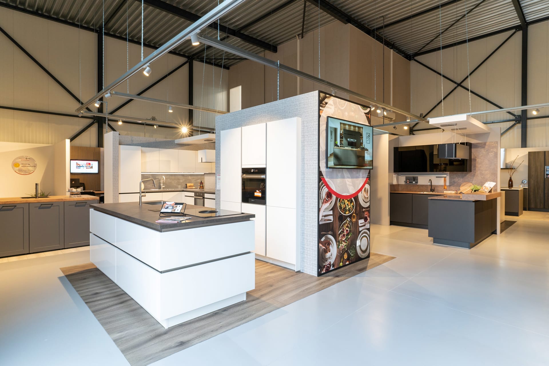 Wit kookeiland tussen verschillende keukenopstellingen in de Kitchen4All-winkel