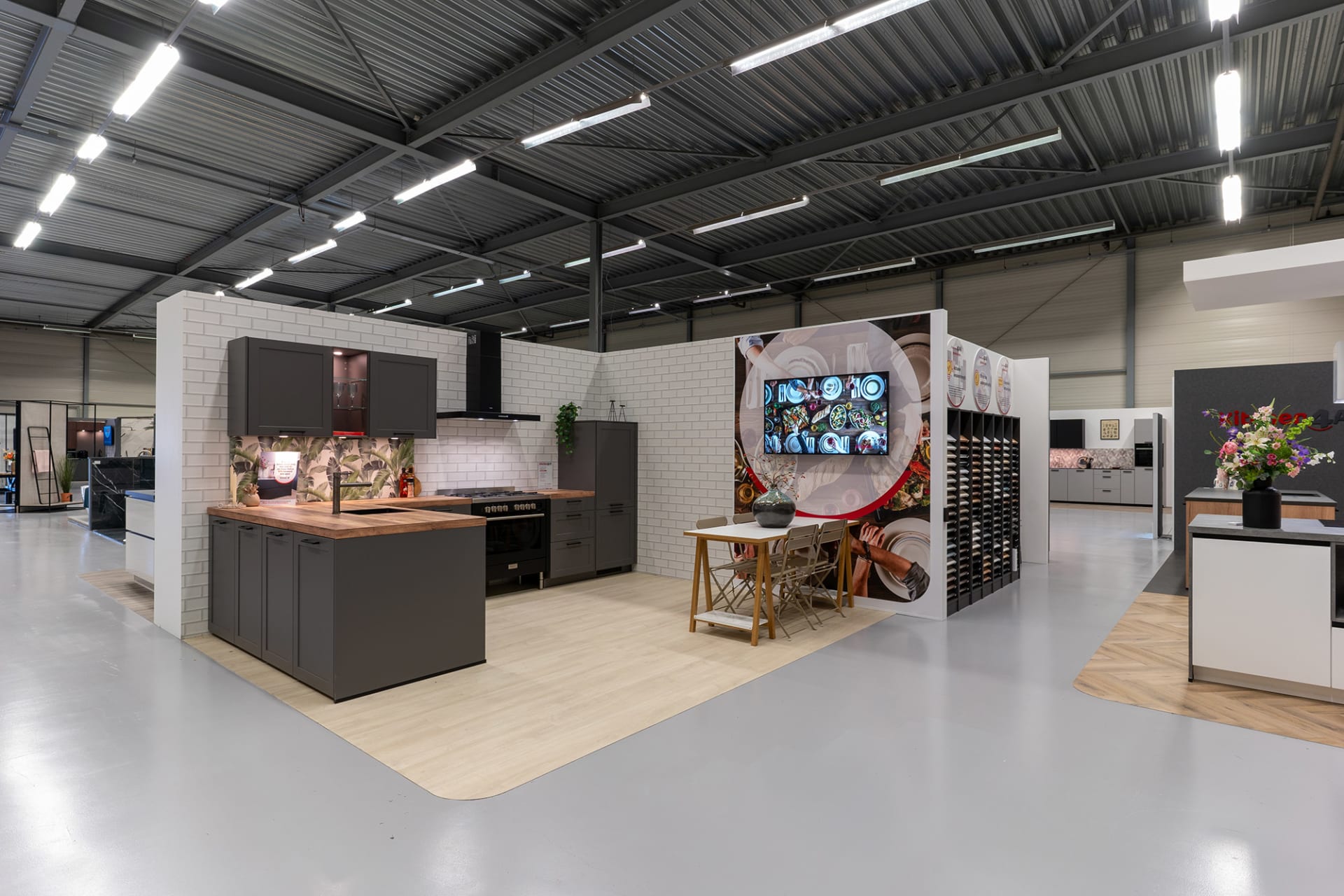 Keukenopstellingen met donkere fronten en een stalenrek in de Kitchen4All-winkel