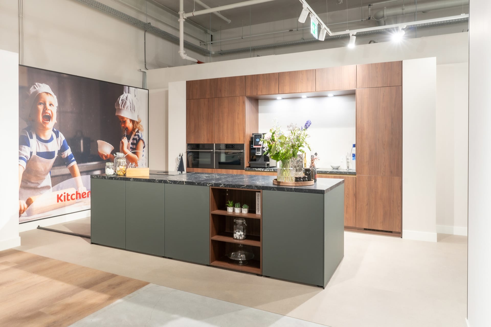 Groengrijs kookeiland voor een notenhouten kastenwand in de Kitchen4All-winkel