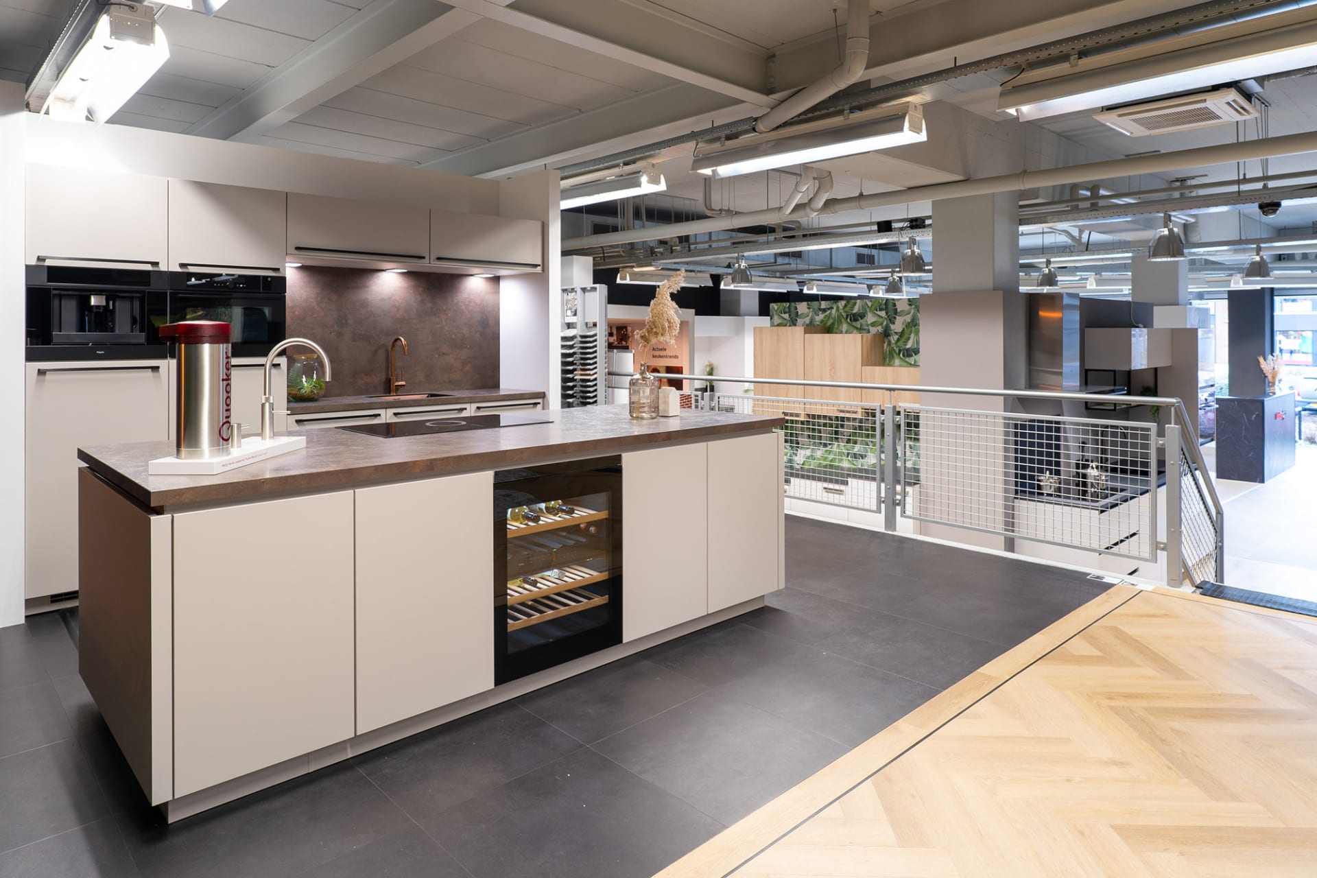 Crème kookeiland met wijnklimaatkast en koperkleurige kraan in de Kitchen4All-winkel