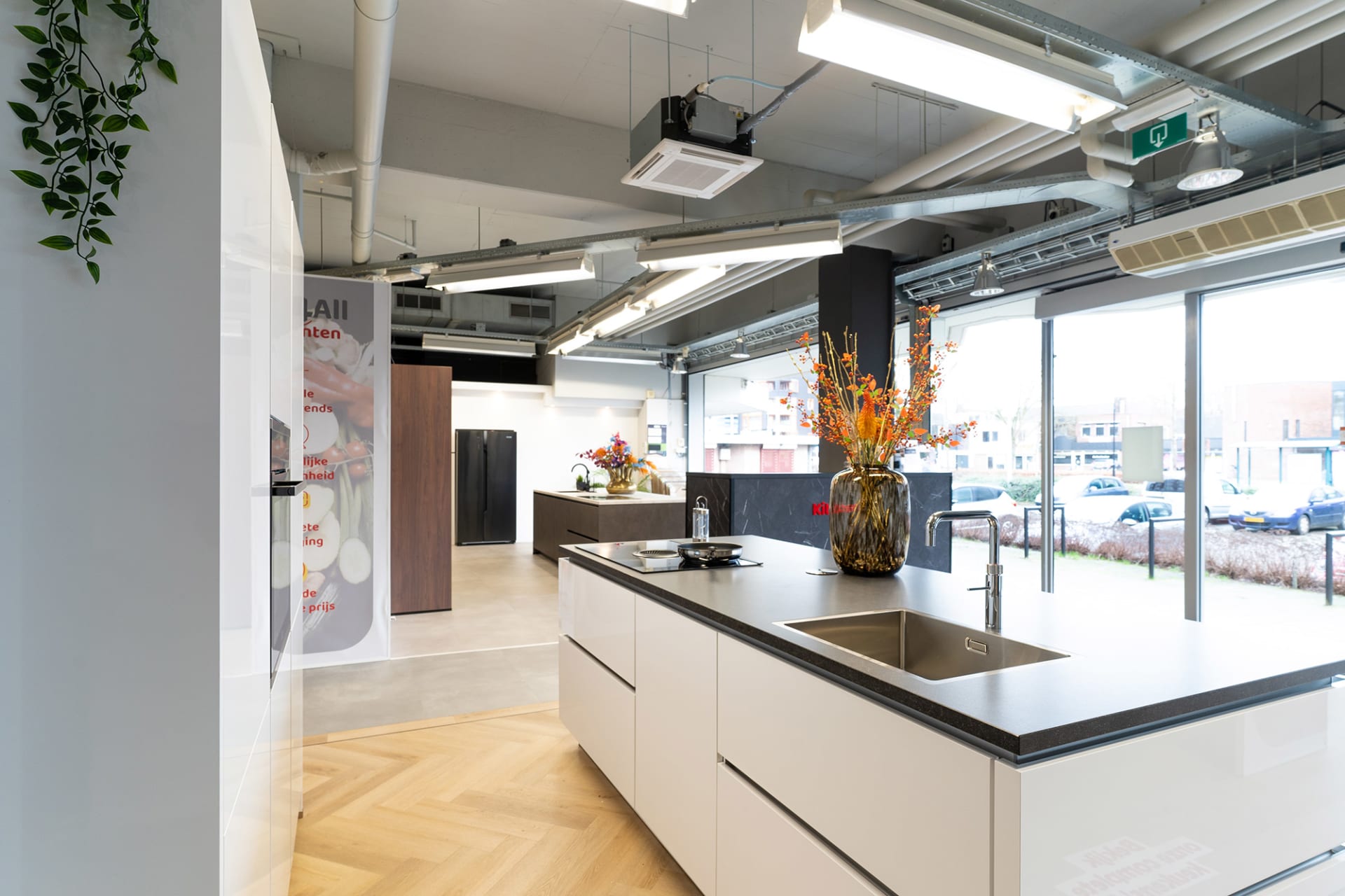Crème kookeiland met kookplaat voor een grote raampartij in de Kitchen4All-winkel