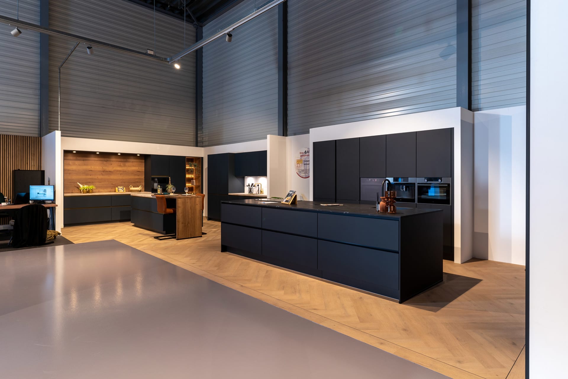 Donkerblauwe eilandopstelling met koperen ketel en donkere kastenwand in de Kitchen4All-winkel