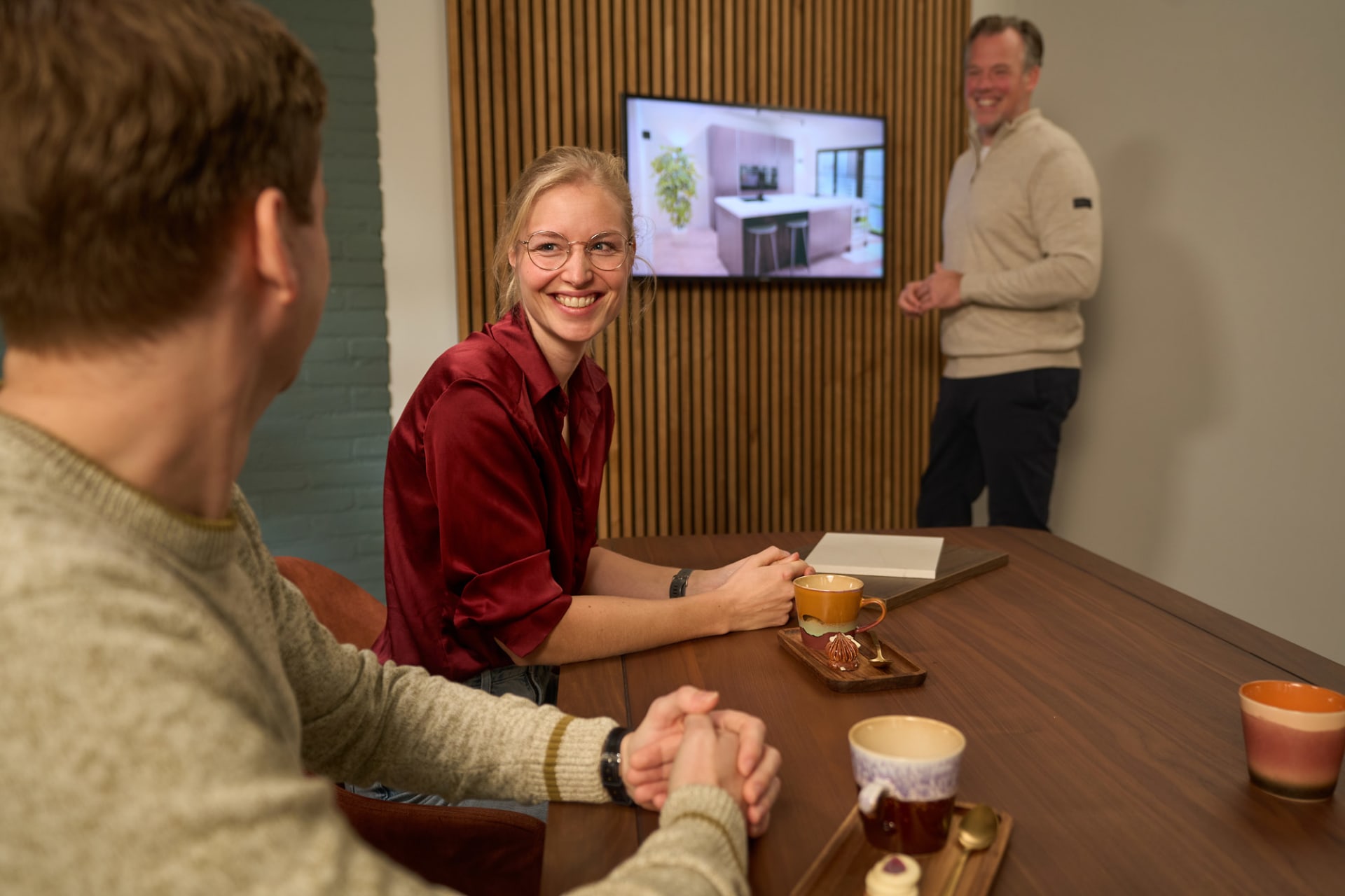 Keukenadviseur toont 3D keuken ontwerp op scherm aan klant