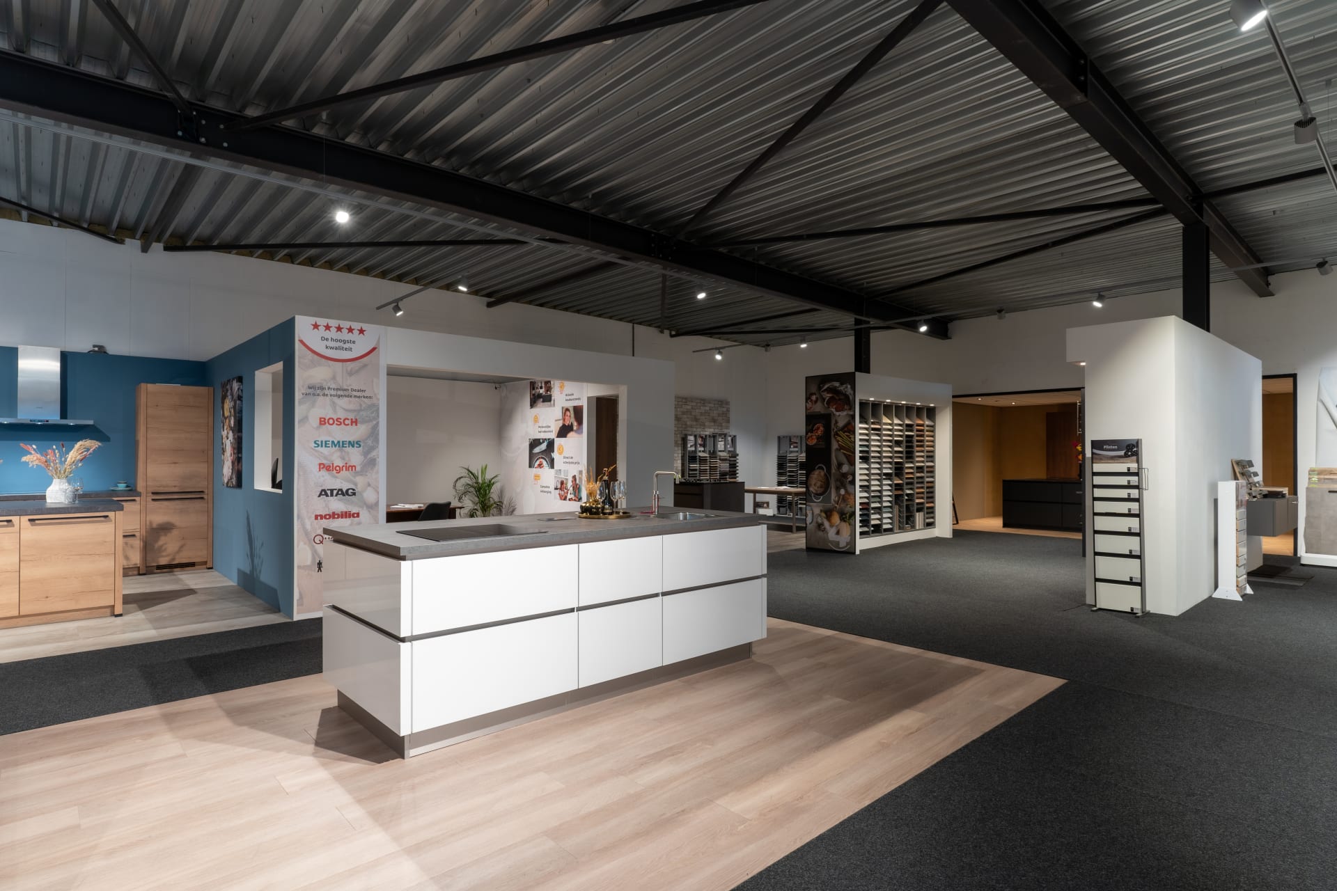 Licht winkelinterieur van Kitchen4All met wit kookeiland en presentatiewanden