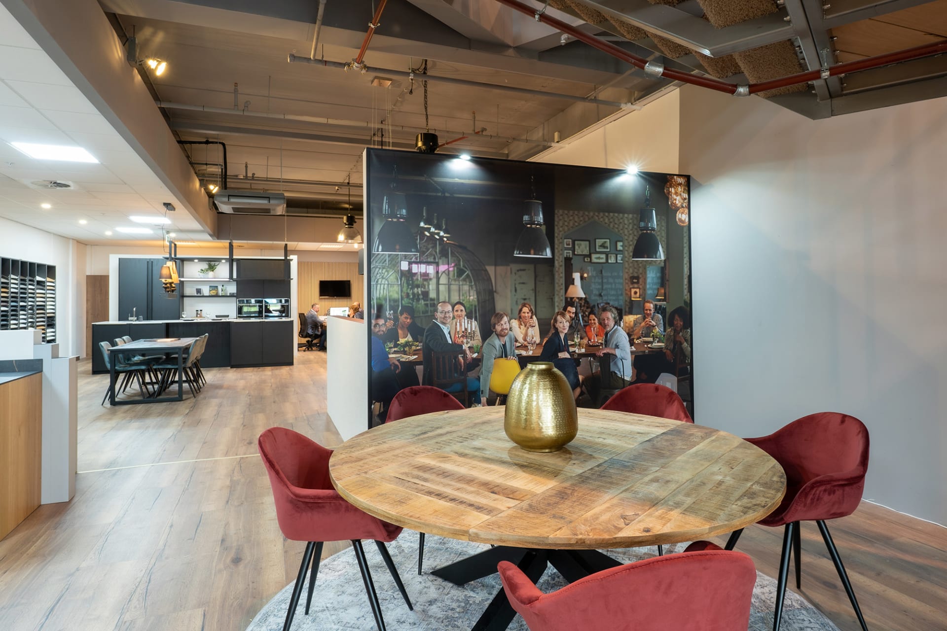 Ronde houten adviestafel met rode stoelen in de Kitchen4All-winkel