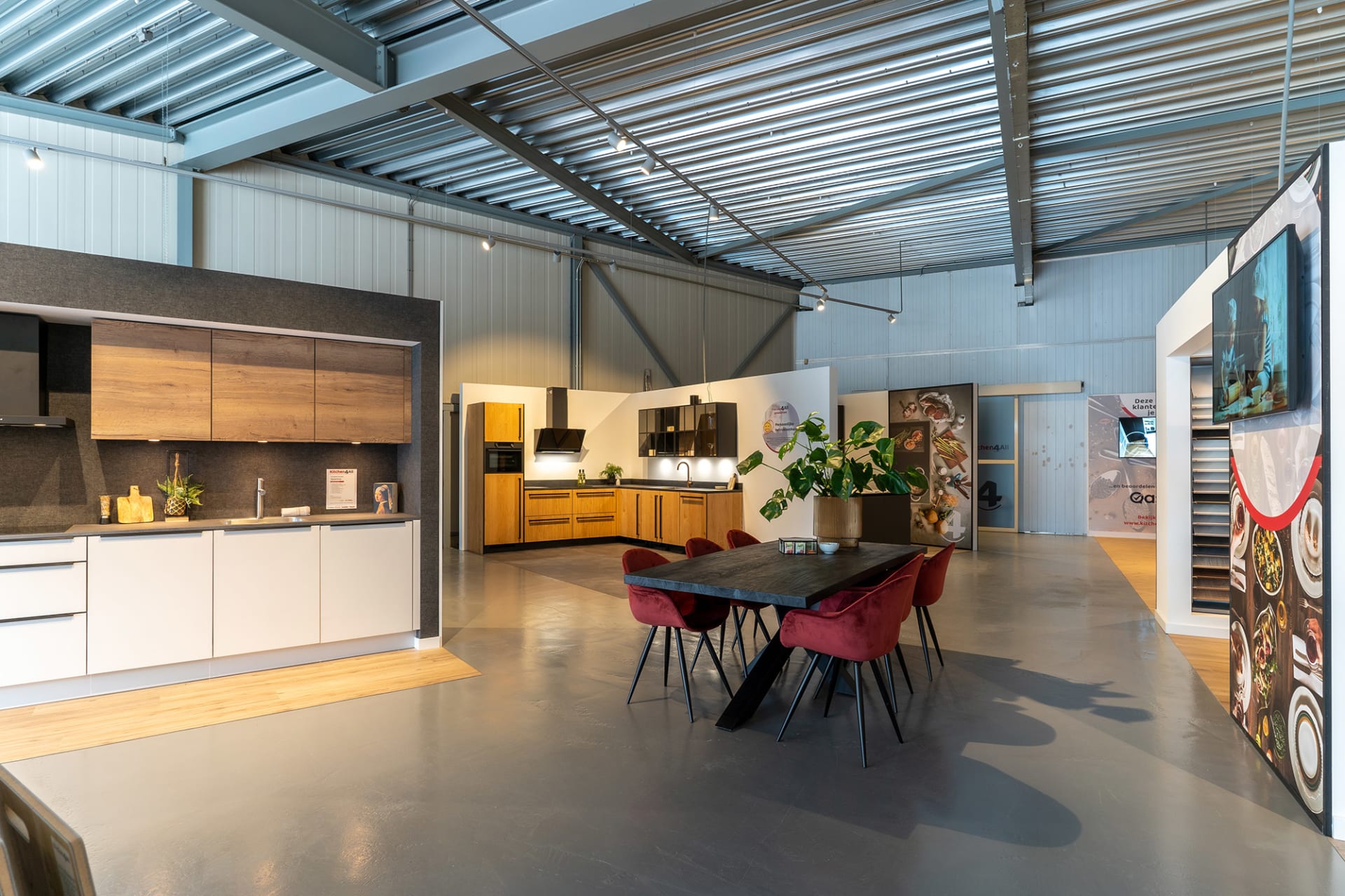 Overzicht van de Kitchen4All-winkel met adviestafel, keukenopstellingen en stalendisplays