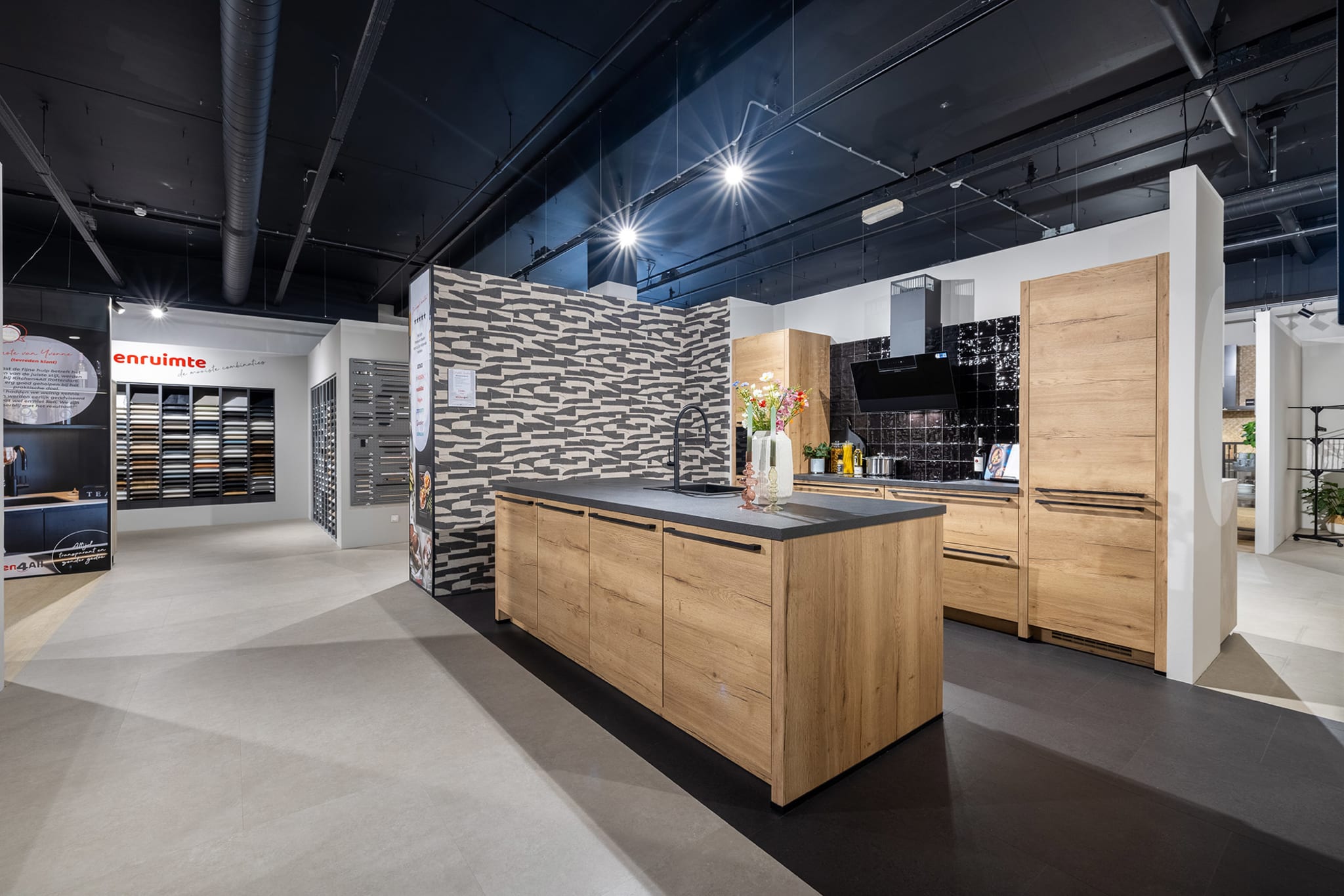 Houten kookeilandopstelling met donkere wandtegels in de Kitchen4All-winkel
