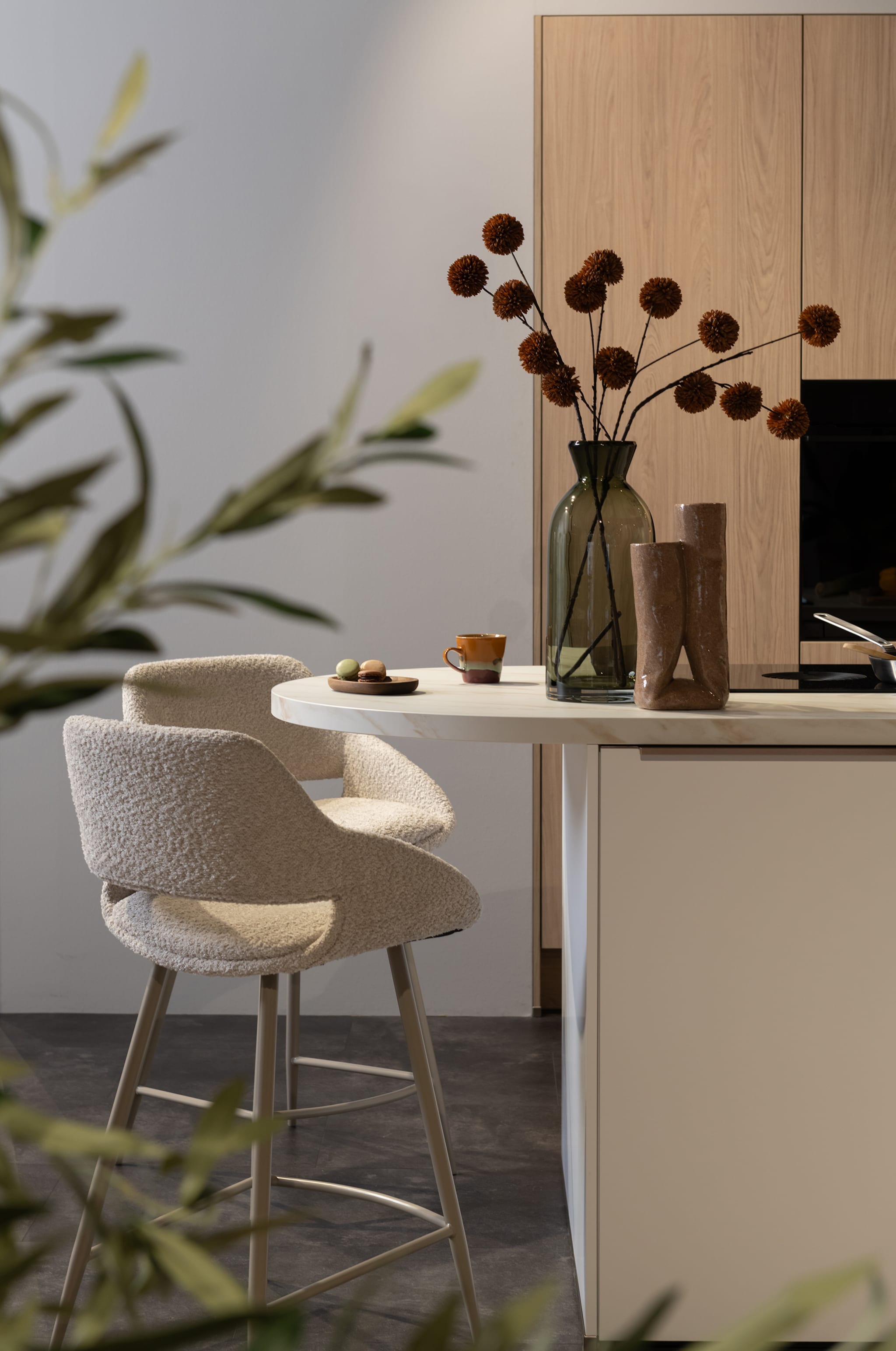 Scandi modern eilandkeuken met greeploze houten fronten en wit werkblad, perfect voor een open ruimte.