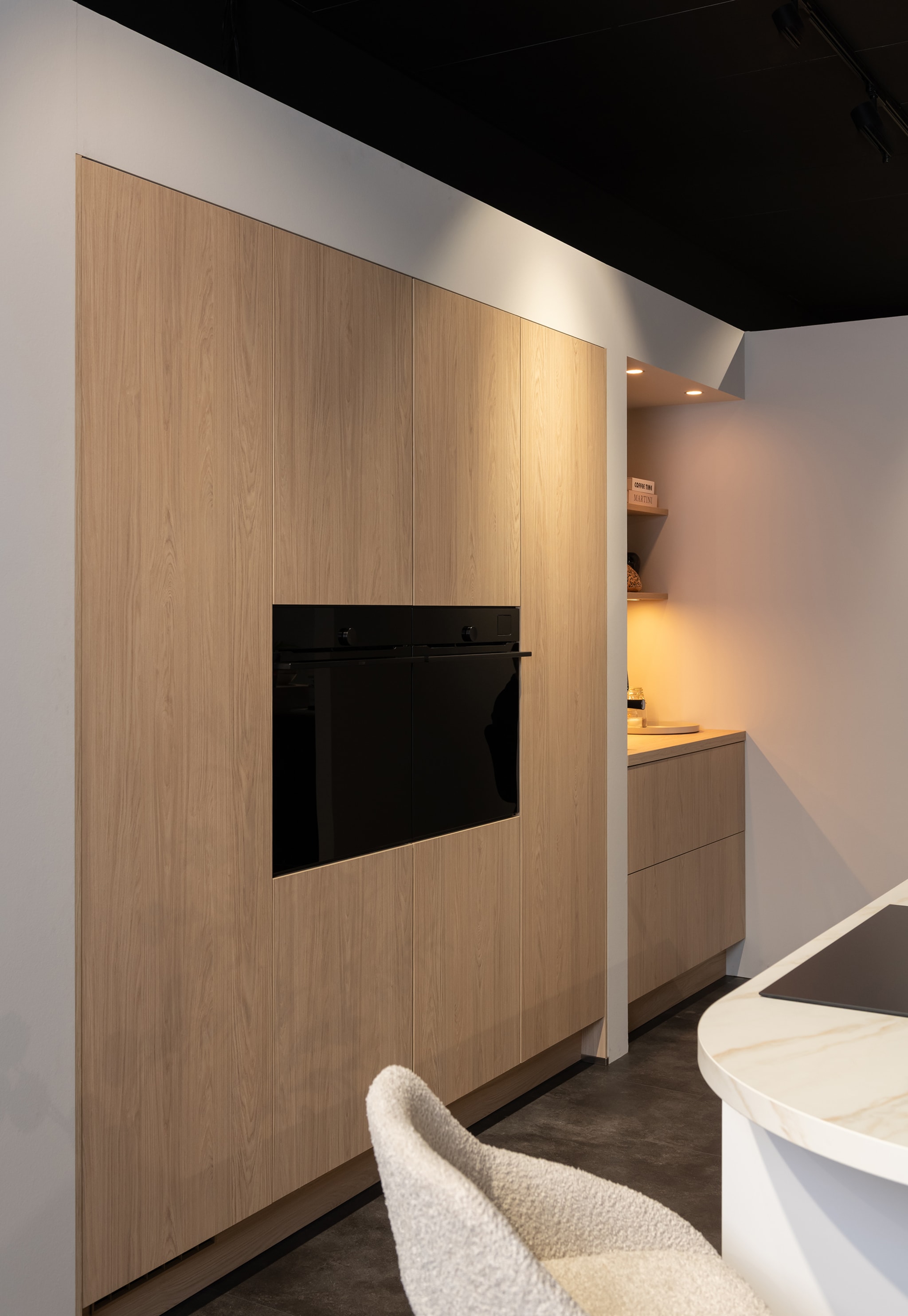 Moderne Kitchen4All keuken met greeploze houtlook fronten en een donker houten werkblad.