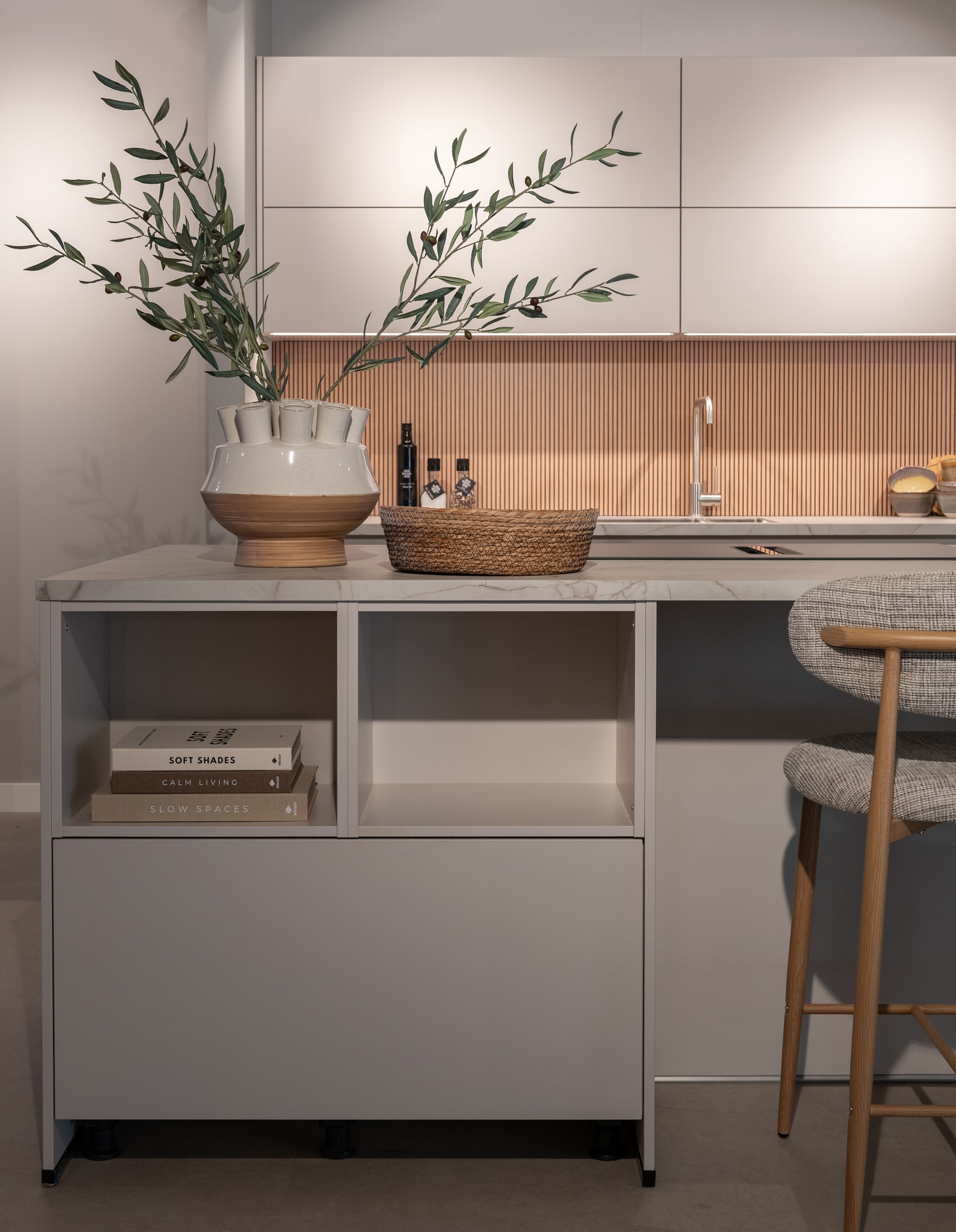 Moderne Nordic warm eiland keuken met greeploze witte matte fronten en een wit composiet werkblad.