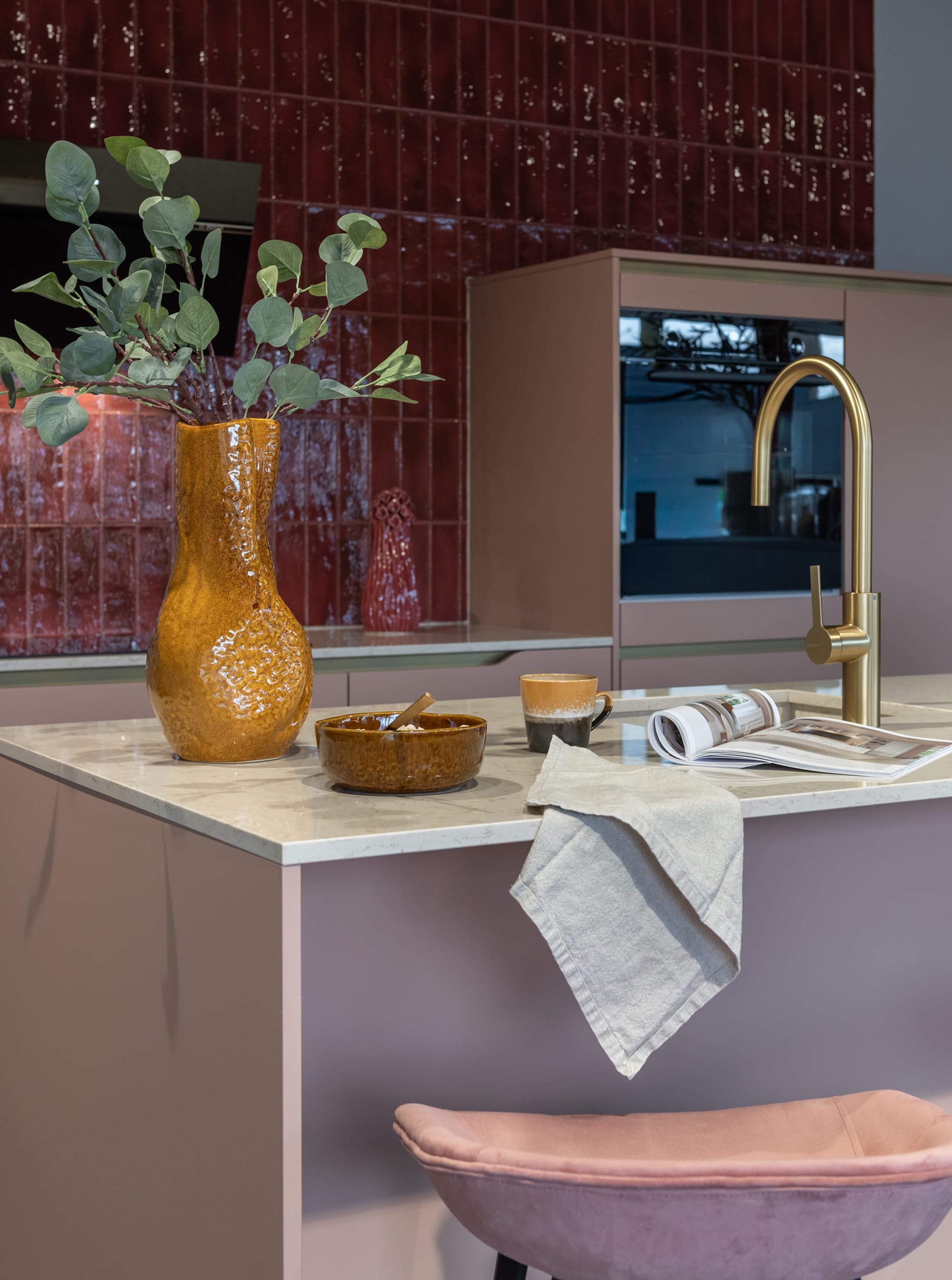 Modern Kitchen4All kookeiland met matte beige en taupe fronten, grijs composiet werkblad en goudkleurige kraan.
