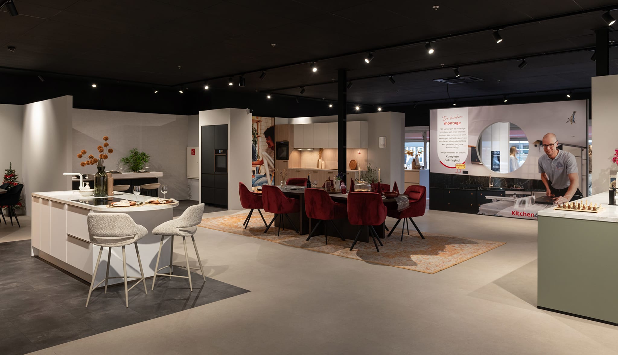 Kitchen4All-winkel in Groningen met een wit kookeiland en een eethoek met rode stoelen