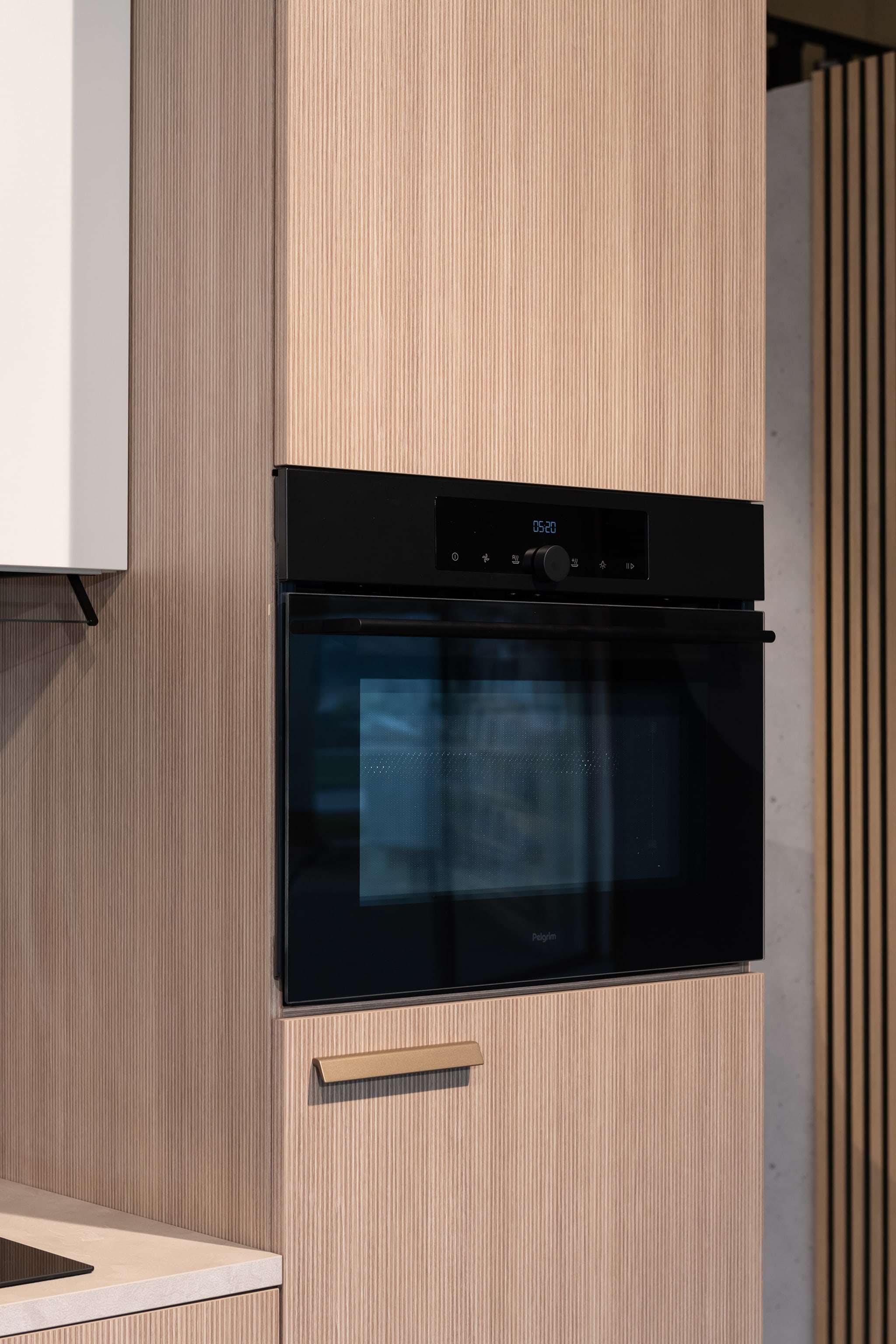 Moderne Japandi soft keuken van Kitchen4All met houtlook fronten en een zwarte inbouw oven.