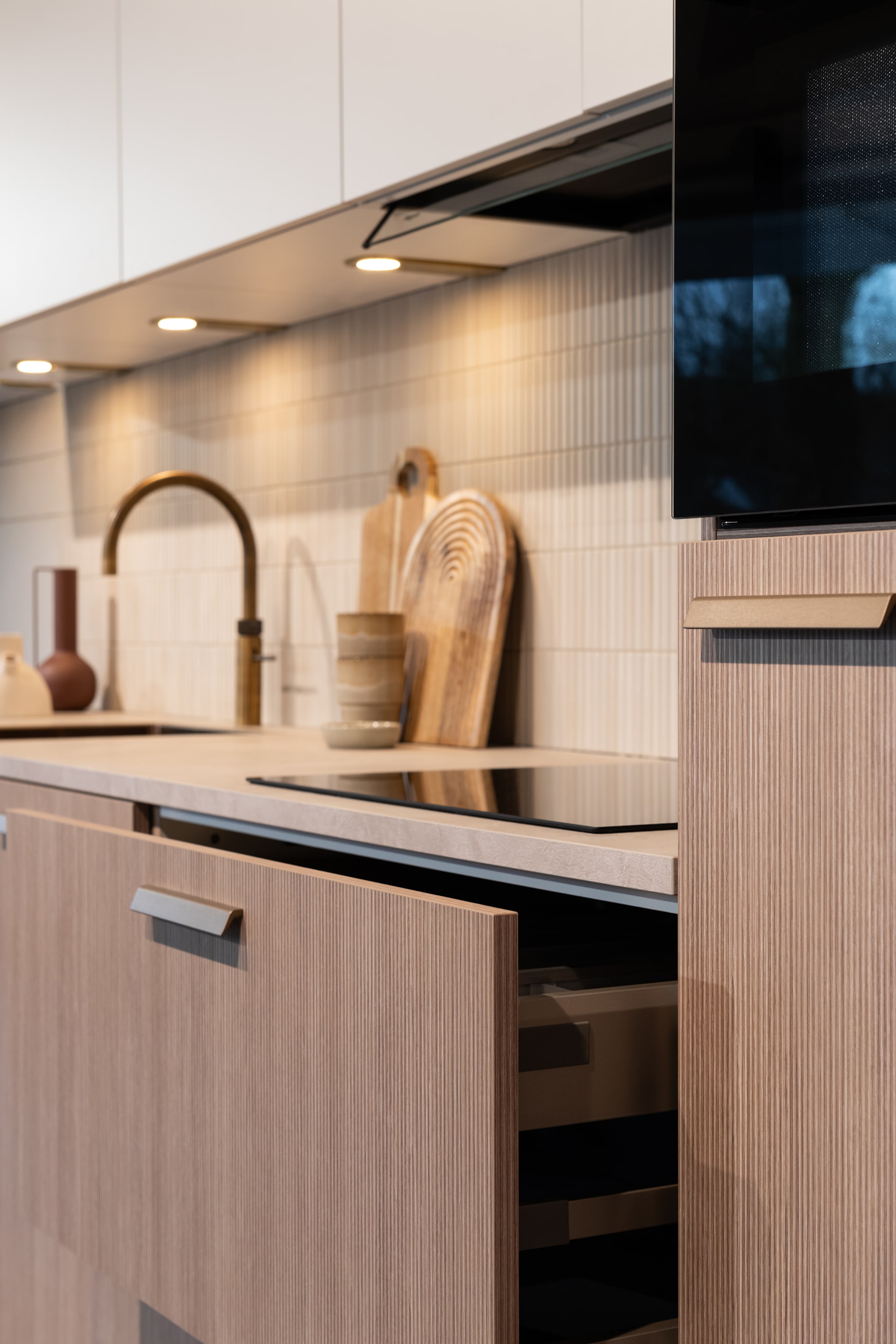 Moderne Japandi soft keuken met houtlook werkblad, houten fronten en greeplijsten, ideaal voor een open en kleine ruimte.