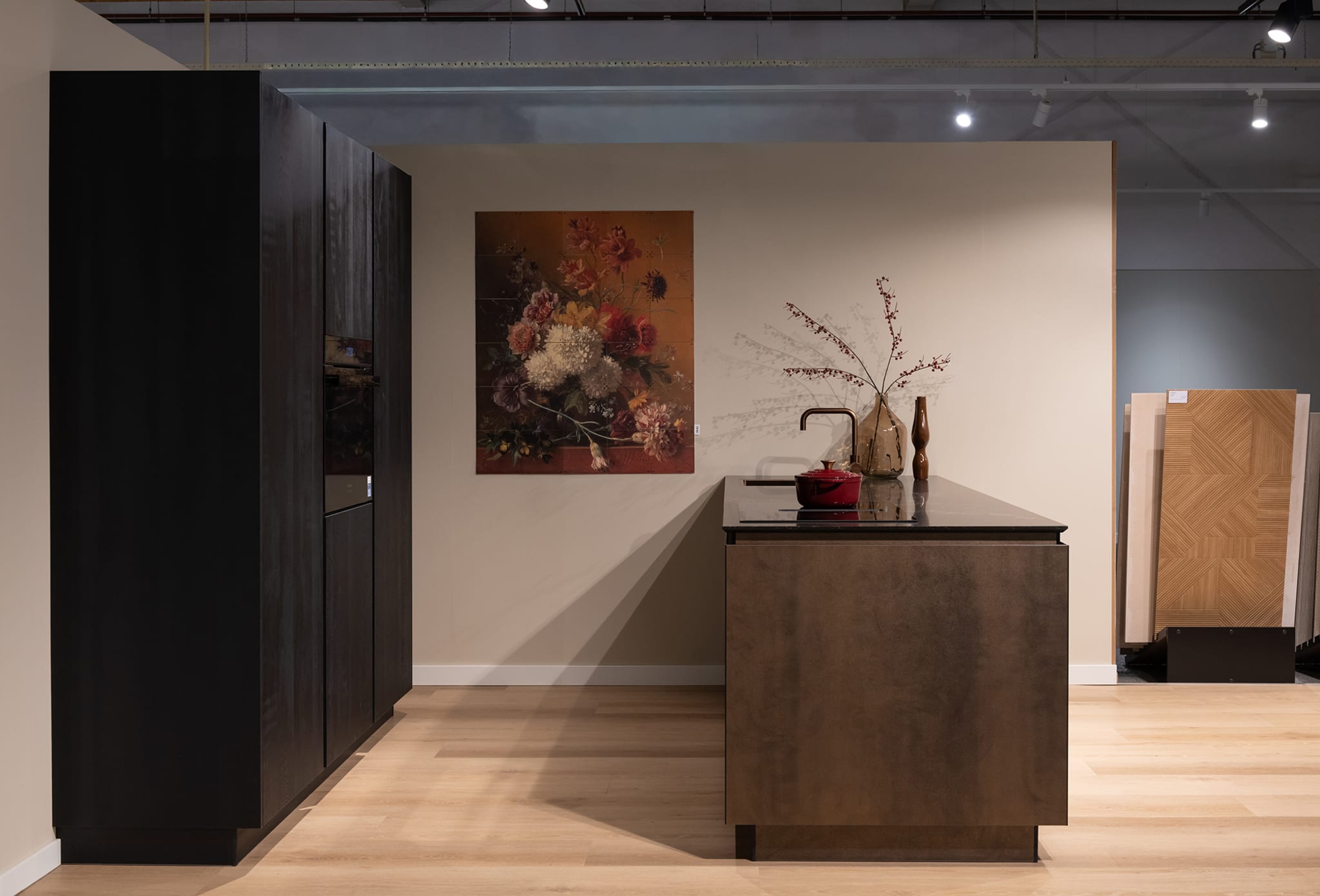 Een moderne, greeploze eilandkeuken van Kitchen4All met donker composiet werkblad en mat houtlook front.