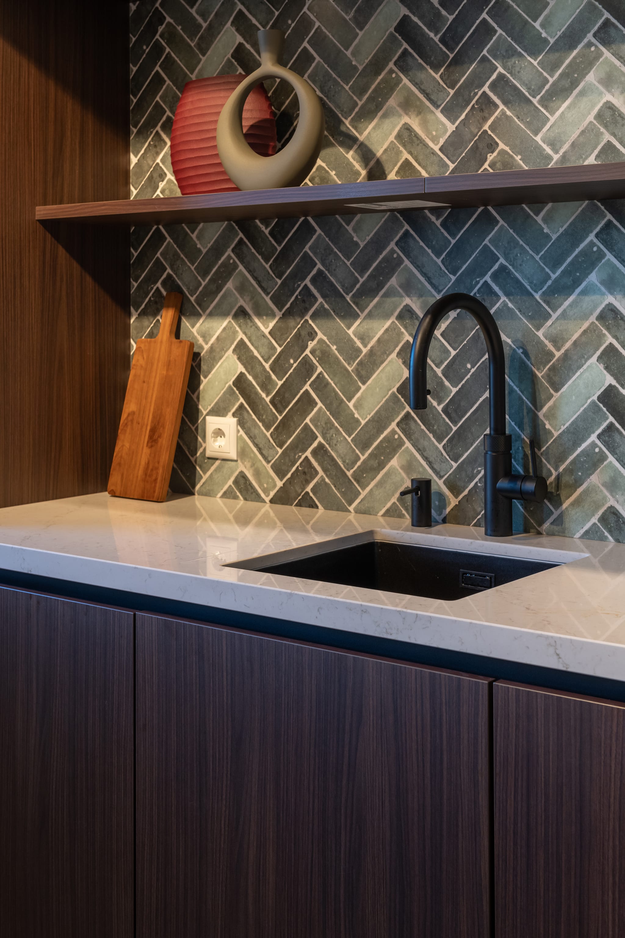 Moderne Kitchen4All keuken met greeploze houtlook fronten, wit werkblad en zwarte kraan.