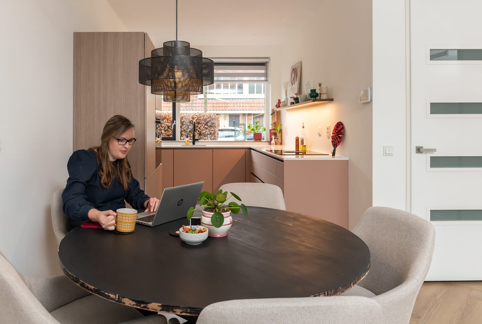 Warme sfeervolle keuken van Jessica met koraalroze fronten en houten ribbelstructuur