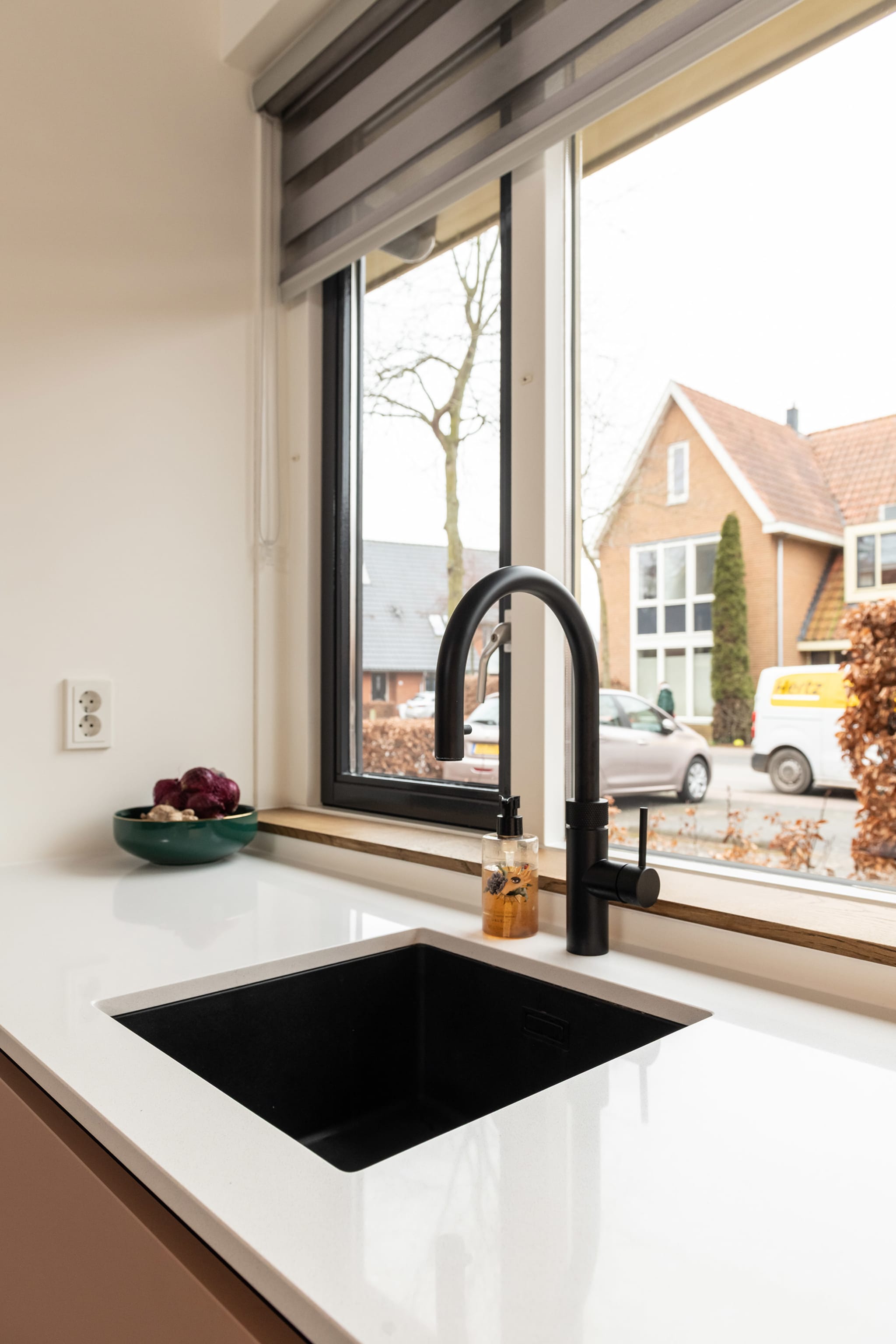 Zwarte Caressi spoelbak met Quooker kraan voor het raam
