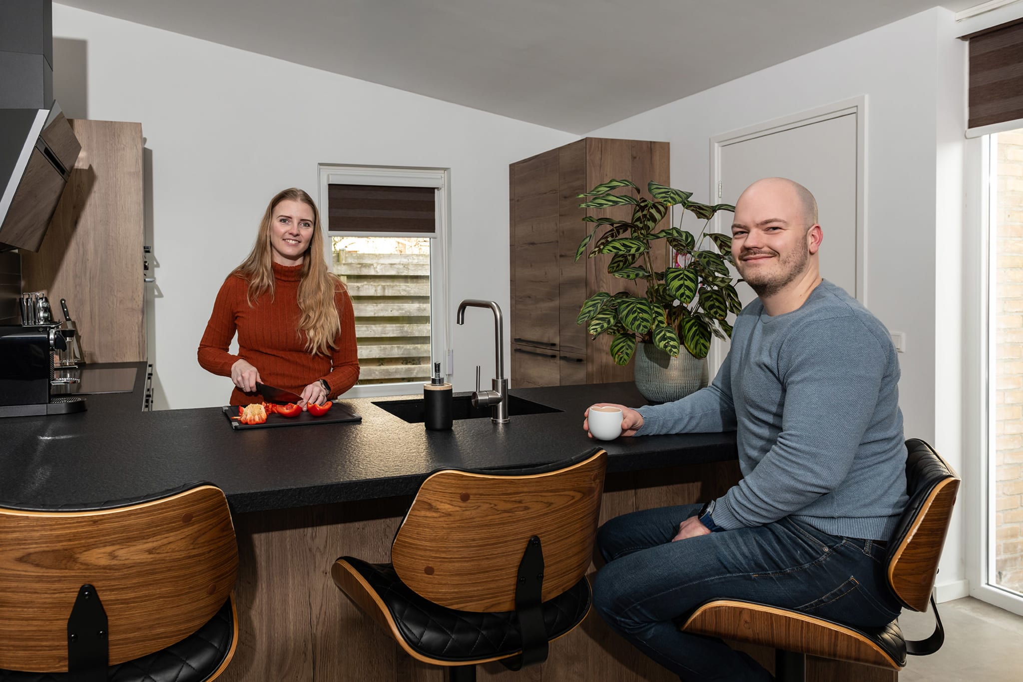 Zwarte afzuigkap boven de inductiekookplaat in de keuken van familie Toersche