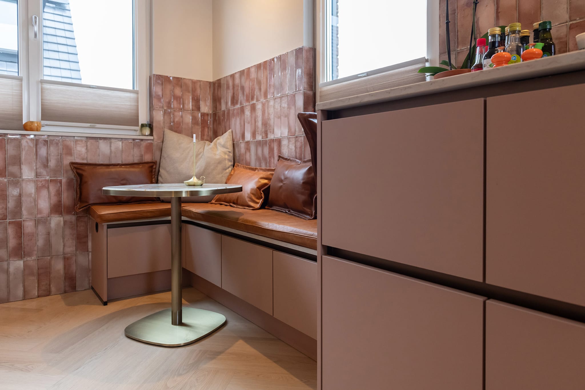 Detail van de greeplijsten en roze fronten in de keuken van Selma
