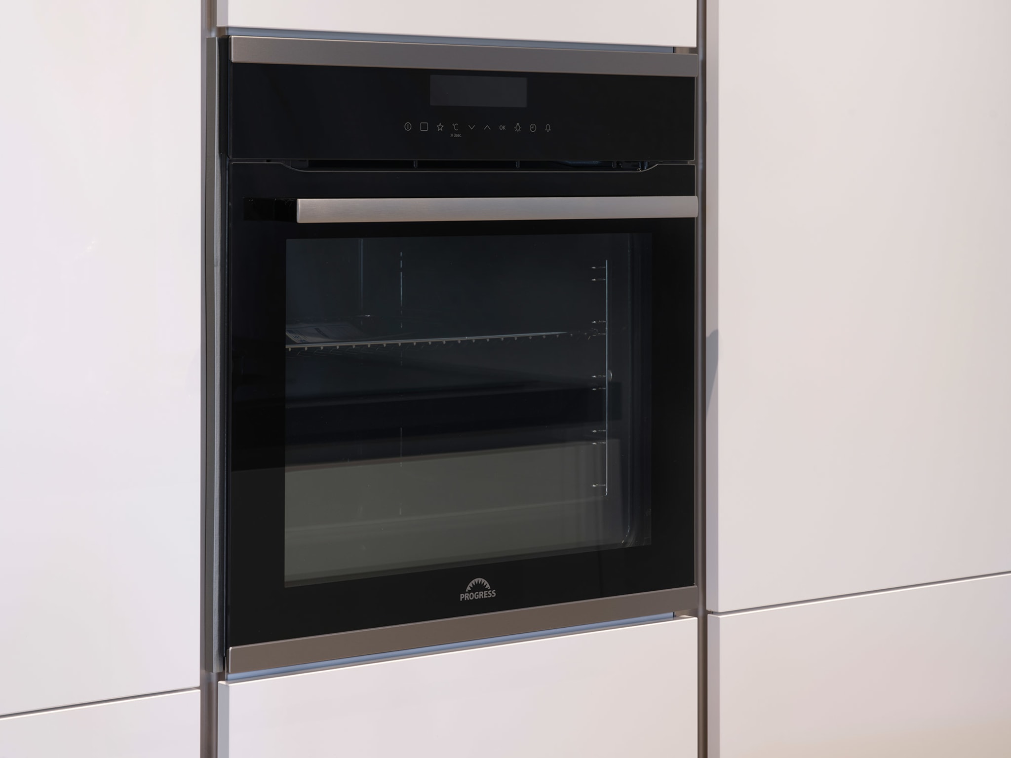 Ingebouwde zwarte oven met handgreep in een moderne, hoogglans witte Kitchen4All keuken.