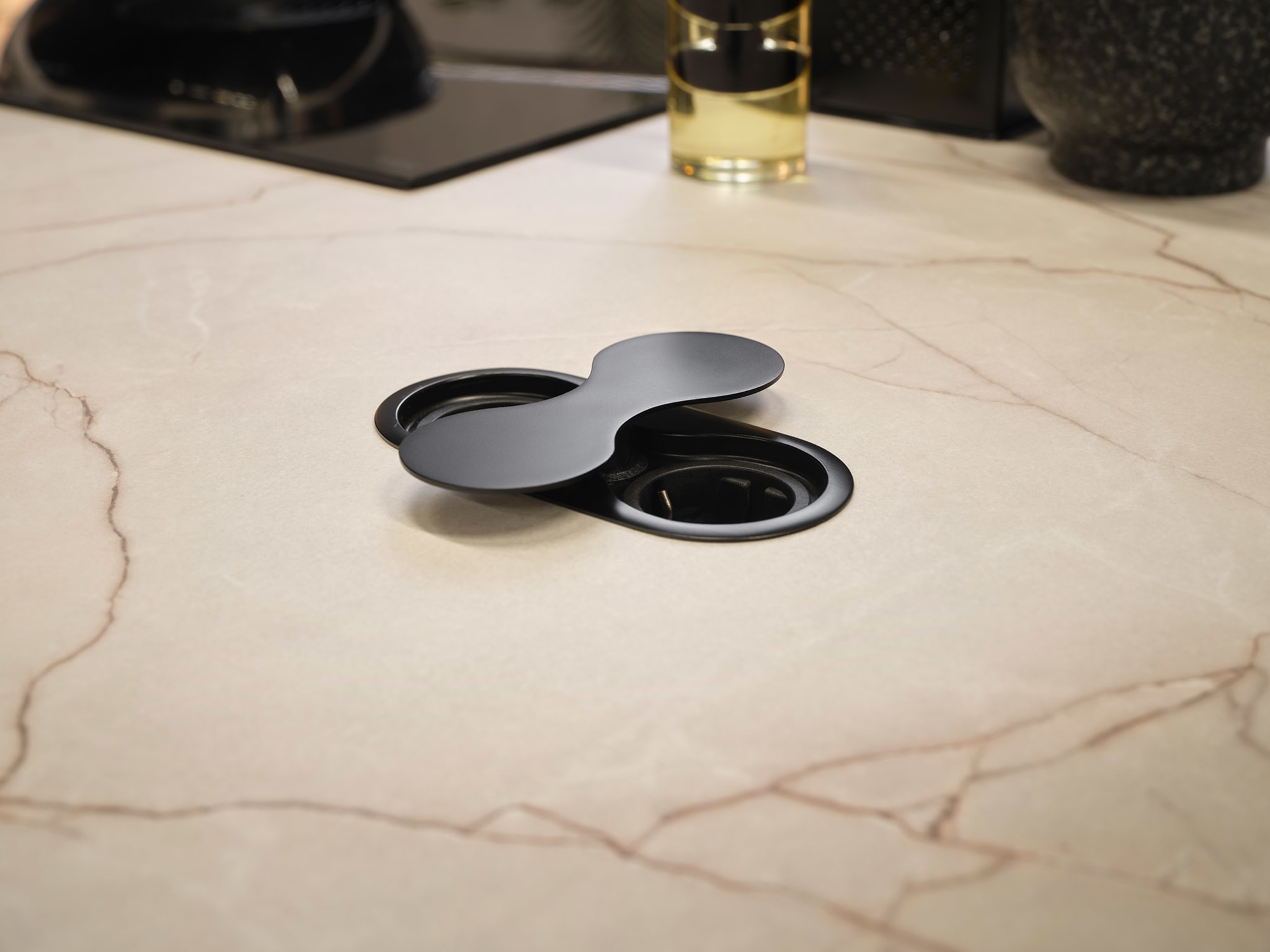 Close-up van een zwart stopcontact in een modern marmerlook composiet werkblad van Kitchen4All.