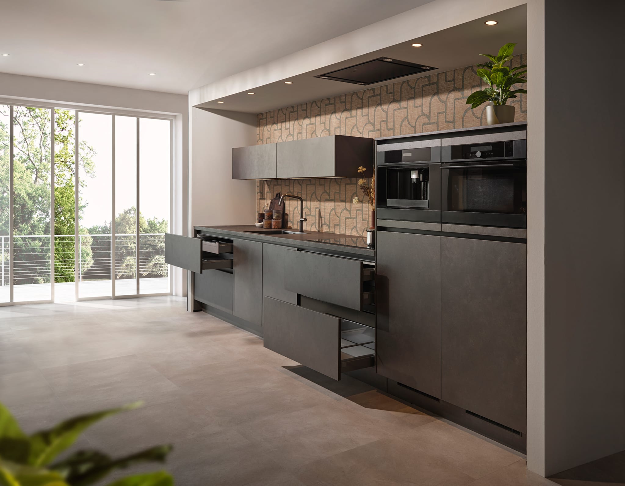 Een moderne, greeploze Kitchen4All keuken met donker composiet werkblad en matte, grijze fronten in een open ruimte.
