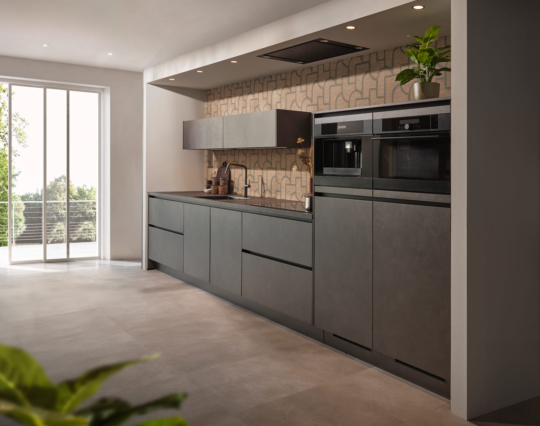 Moderne rechte Kitchen4All keuken met grijze matte fronten, donker composiet werkblad en greeplijsten.