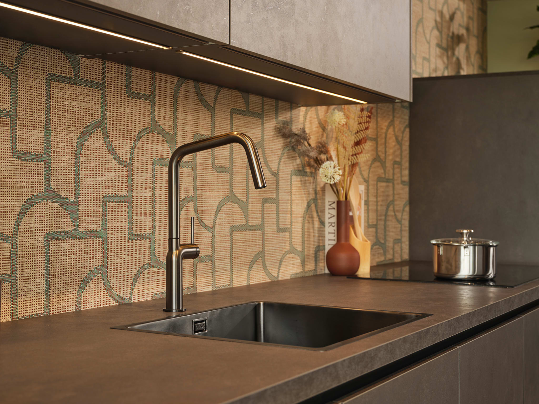 Moderne Kitchen4All keuken met greeploze zwarte fronten en donkergrijs composiet werkblad in betonlook.