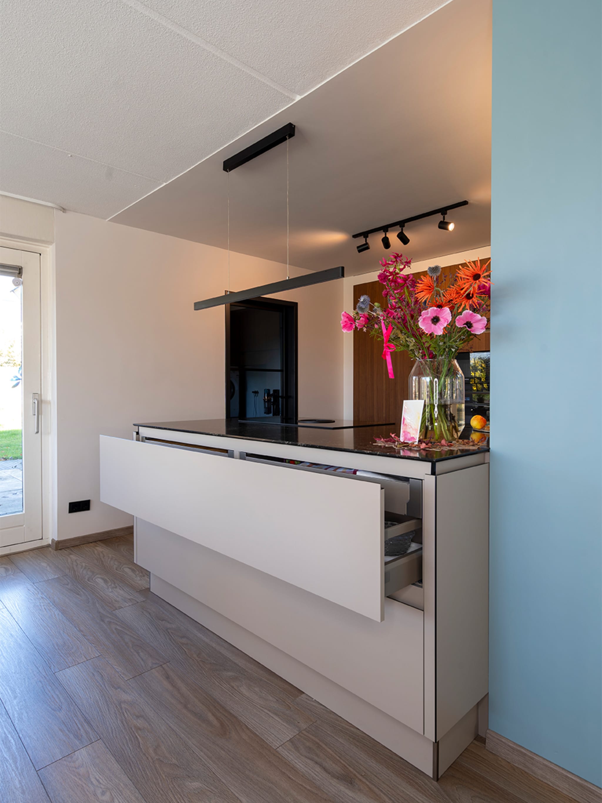 Hoge kastenwand met inbouwapparatuur en notenhoutlook fronten