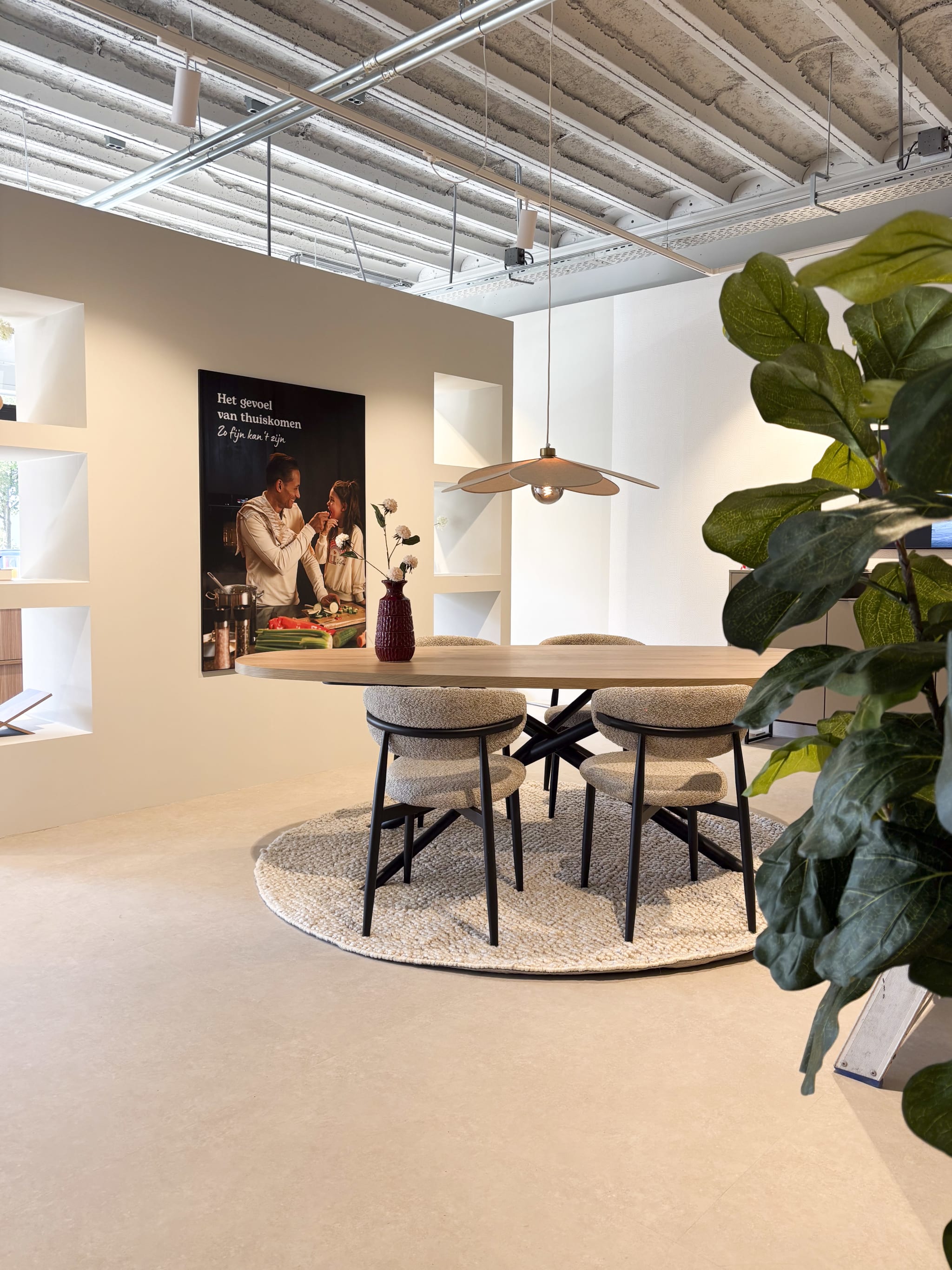 Eethoek met een ronde tafel en bouclé stoelen in de winkel van Kitchen4All Assen