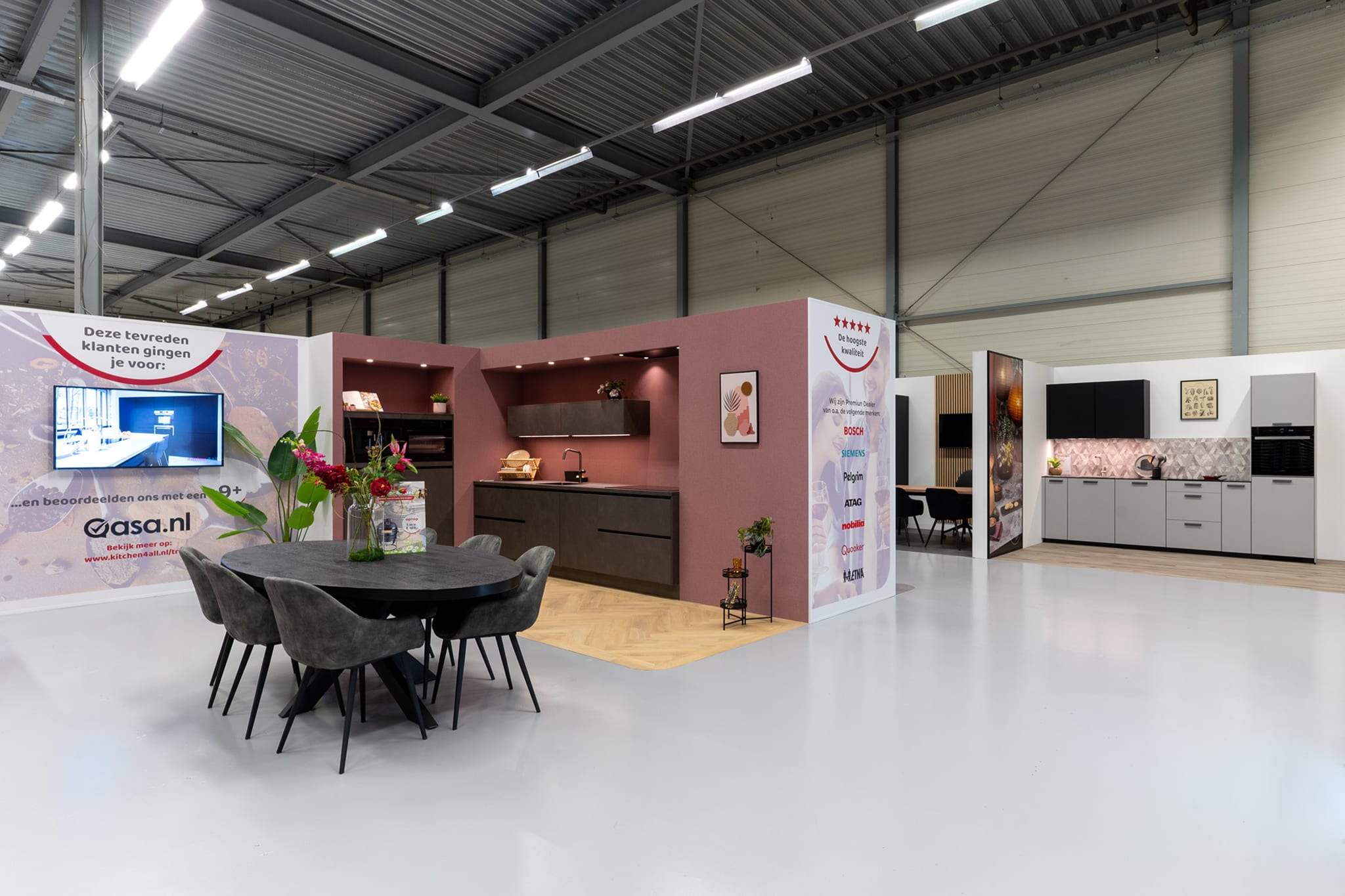 Keukenopstellingen langs een bordeauxrode wand in de Kitchen4All-winkel