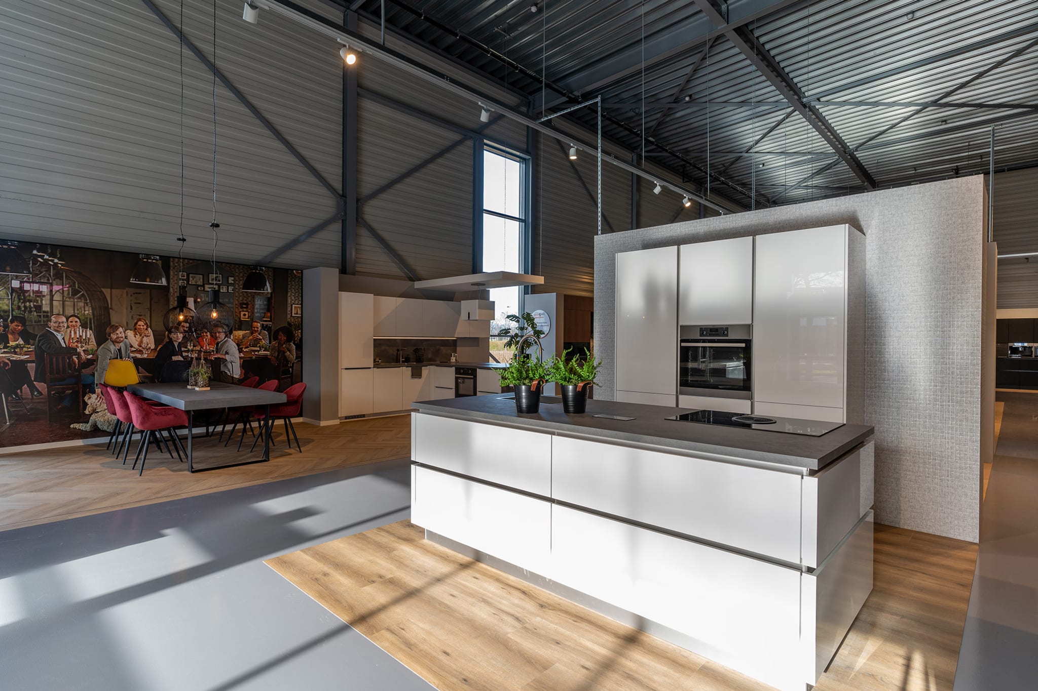 Wit hoogglans kookeiland in een lichte keukenwinkel van Kitchen4All