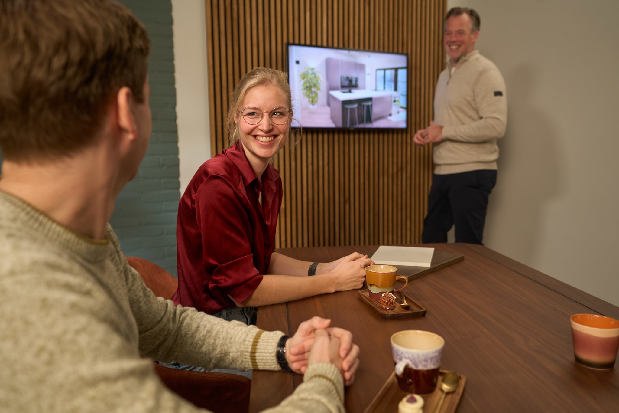 Klanten bekijken een 3D-keukenontwerp op een scherm tijdens een adviesgesprek bij Kitchen4All
