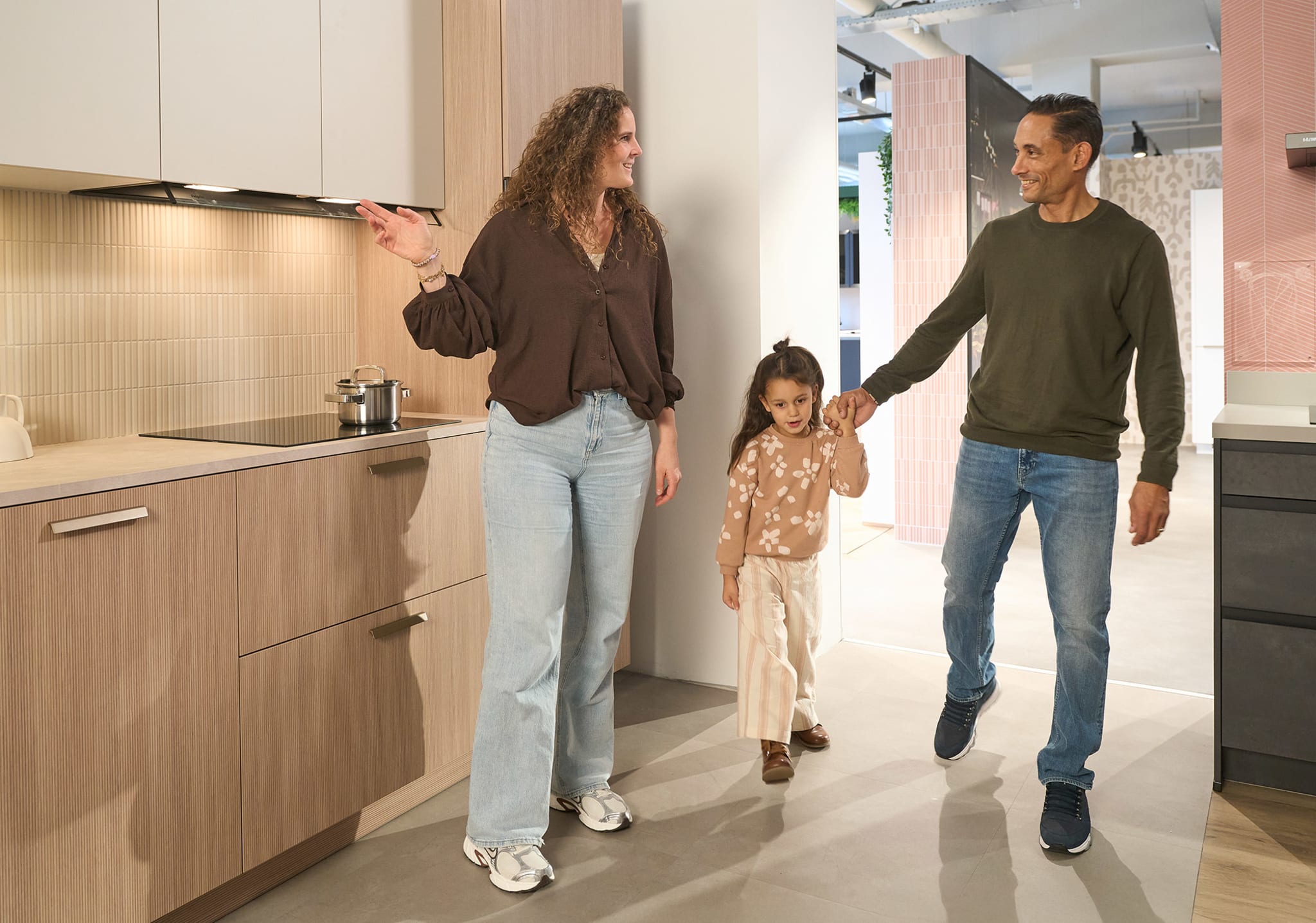 Gezin bekijkt een houtlook keukenopstelling in een Kitchen4All-winkel