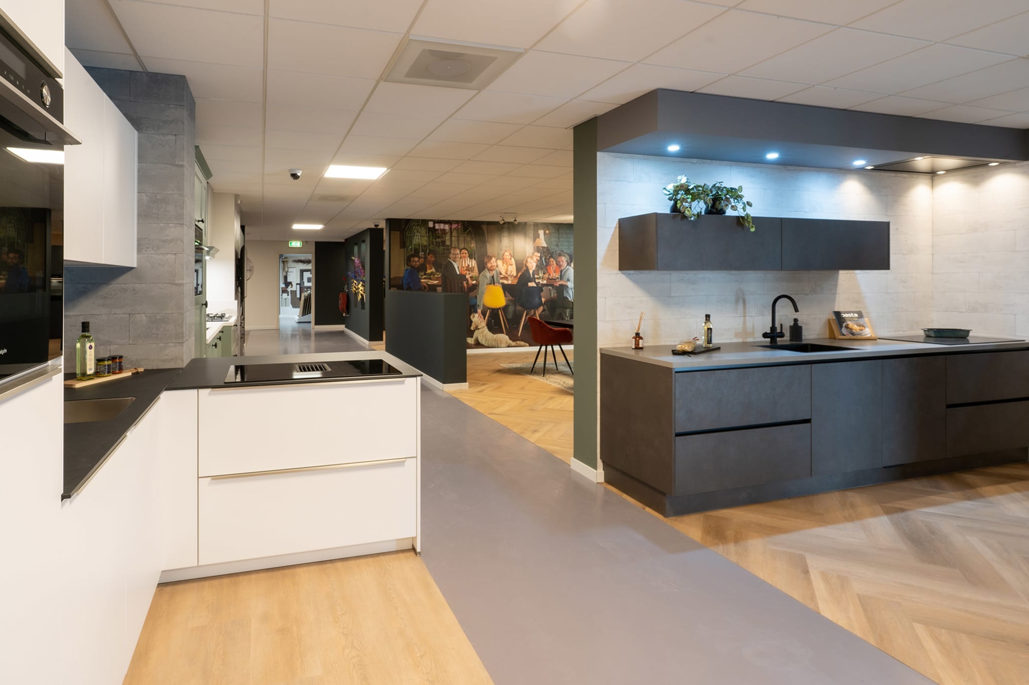 Witte hoekkeuken naast een donkergrijze keukenwand in de Kitchen4All-winkel