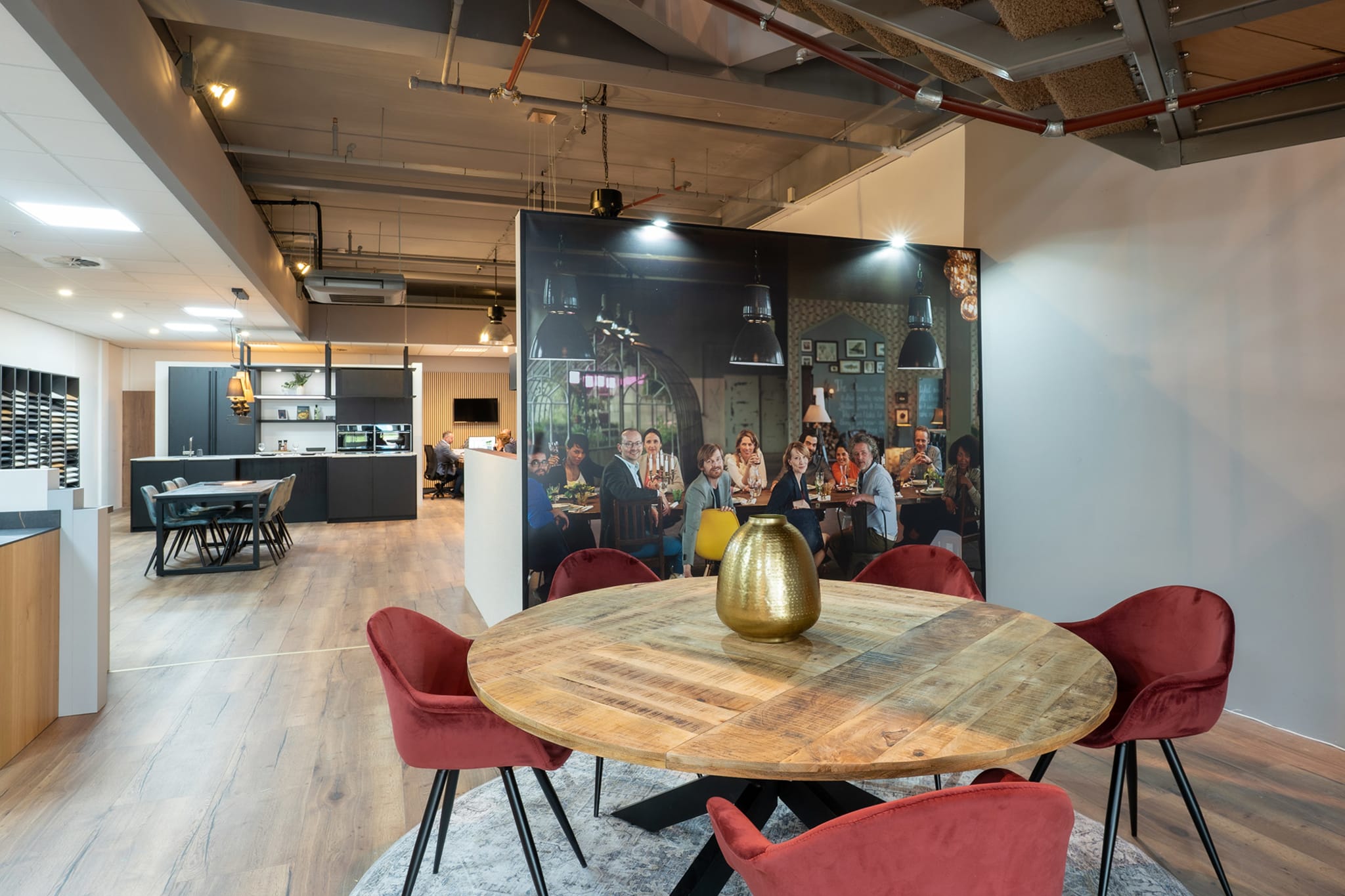 Ronde houten adviestafel met rode stoelen in de Kitchen4All-winkel