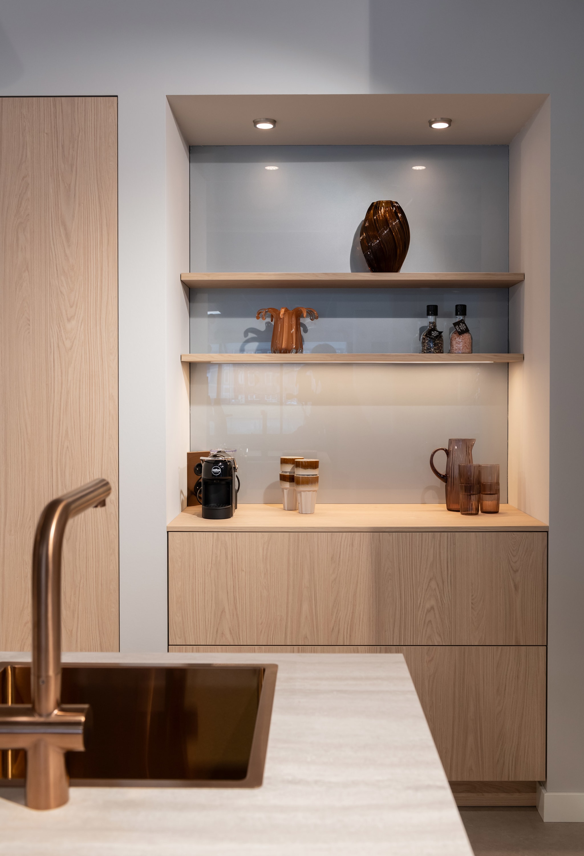 Een Scandi modern eilandkeuken van Kitchen4All met greeploze houten fronten en een marmerlook composiet werkblad.