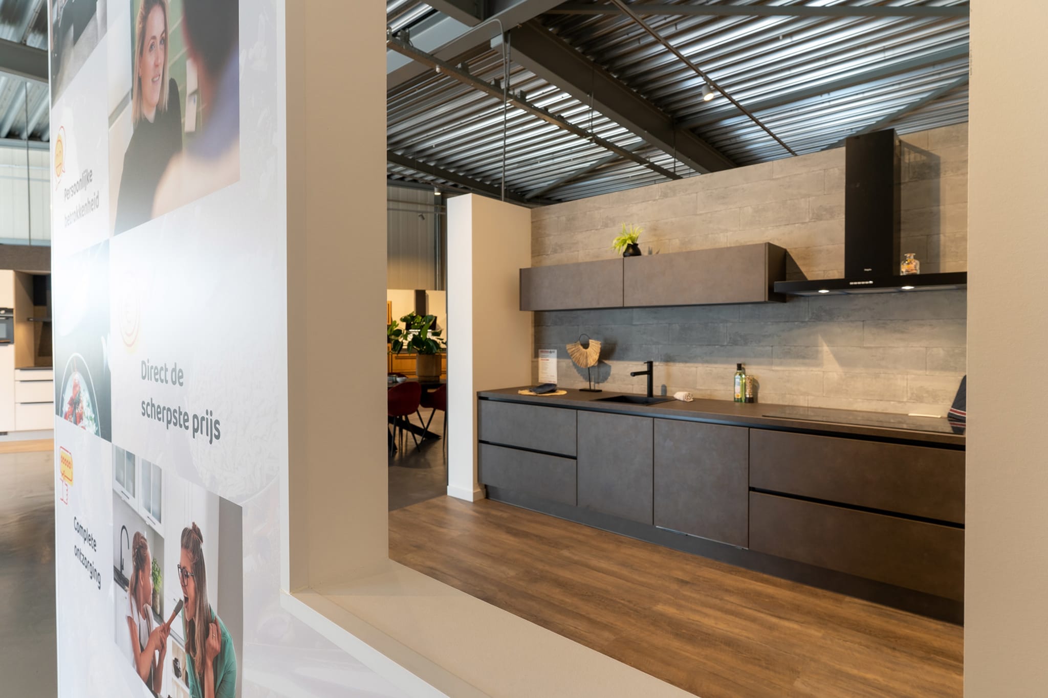 Donkere keuken met betonlook fronten en een strakke wandkast