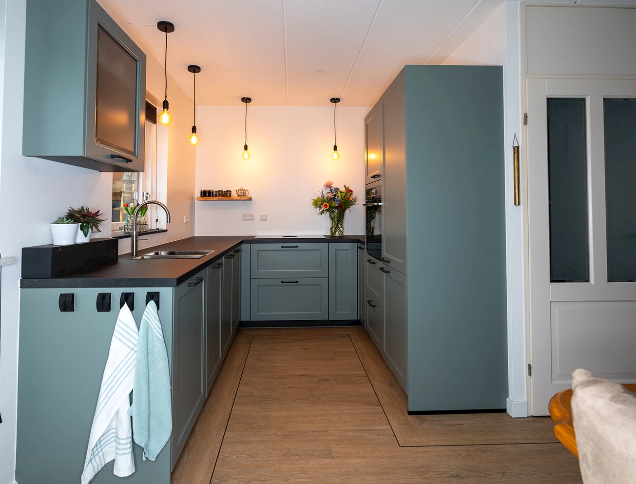 Kleurrijke U-keuken met kastenwand