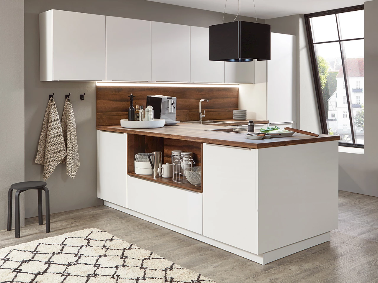 Witte keuken met een houtlook werkblad en schiereiland