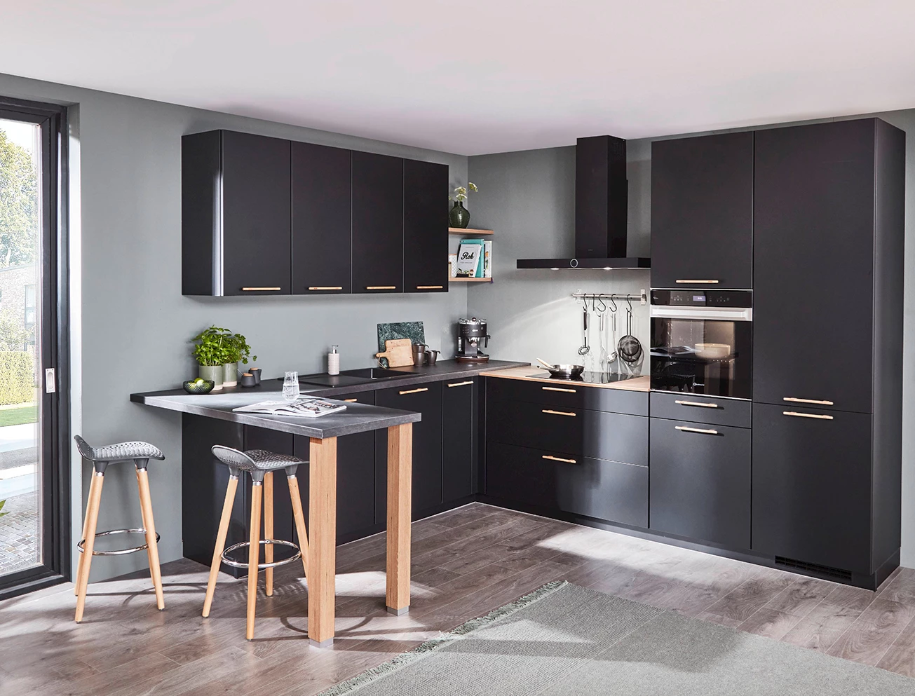 Zwarte hoekkeuken met een houten bar en barkrukken