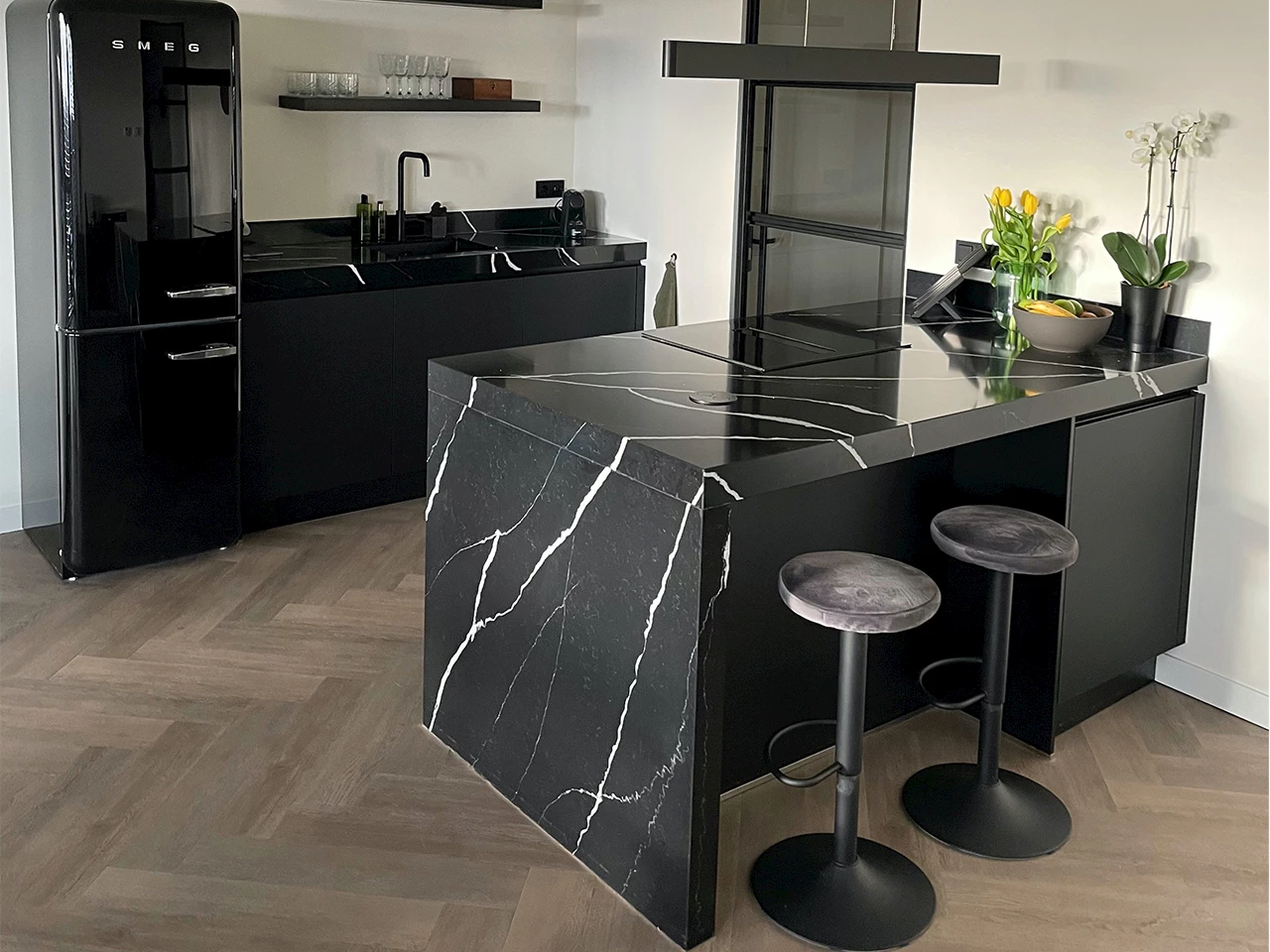 Zwarte keuken met zwart marmeren eiland met witte adering